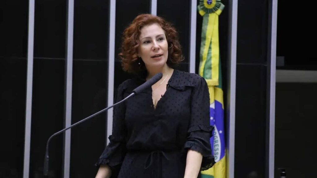 De acordo com o site Terra Brasil Notícias, a Procuradoria-Geral da República (PGR) solicitou o arquivamento de um inquérito contra a ex-deputada federal Carla Zambelli. O pedido reacende discussões sobre os limites entre o discurso político e possíveis crimes contra instituições. A ex-parlamentar, que atualmente enfrenta um processo de extradição após ser presa em Roma, estava sob investigação por suposta coação contra o Supremo Tribunal Federal (STF). A publicação destaca que a decisão da PGR levanta questões sobre a interpretação das ações de Zambelli e o que pode ser considerado como parte do exercício legítimo de sua atividade política. Segundo a publicação, a PGR justificou o pedido de arquivamento com base na análise de que as ações de Zambelli não configurariam crime, mas sim uma manifestação de sua atuação política. A decisão ocorre em um contexto de crescente debate sobre a liberdade de expressão de políticos e os limites legais dessa liberdade quando confrontada com a proteção das instituições democráticas. O site ressalta que a situação de Zambelli é complexa, pois além do inquérito no Brasil, ela enfrenta um processo de extradição na Itália, o que adiciona uma camada internacional ao caso. O Terra Brasil Notícias informa que o pedido de arquivamento ainda precisa ser analisado pelo Supremo Tribunal Federal, que decidirá se aceita ou não a recomendação da PGR. Enquanto isso, o caso continua a ser um ponto de discussão sobre a relação entre política e justiça no Brasil. A publicação sugere que o desfecho desse caso poderá ter implicações significativas para outros políticos que enfrentam acusações semelhantes, além de influenciar o debate público sobre a responsabilidade e os limites do discurso político no país.
