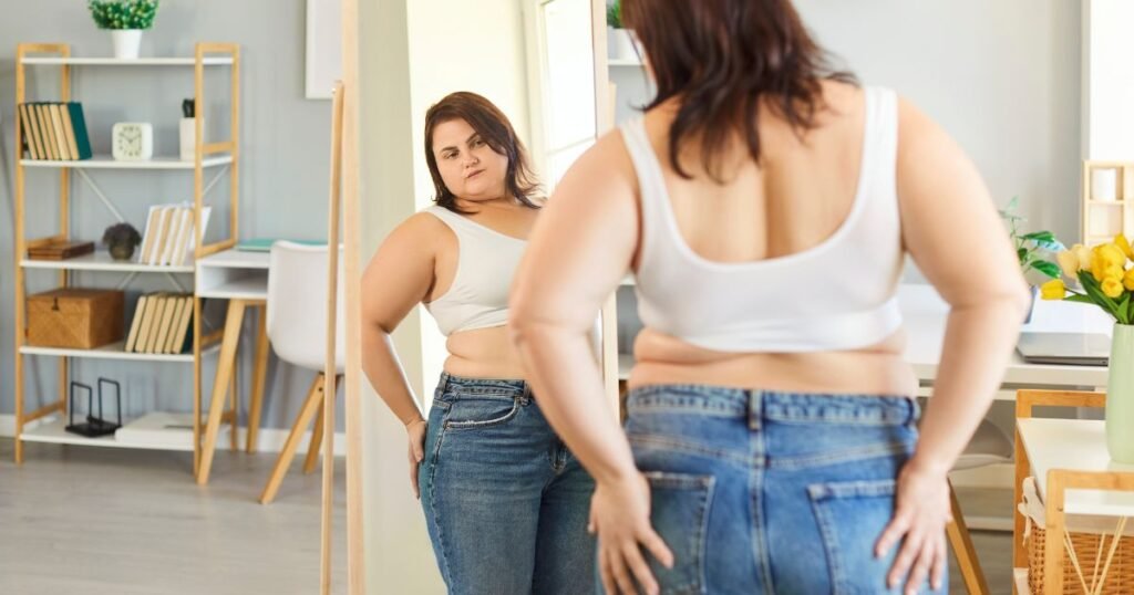 Como a gordura corporal pode revelar suas dores emocionais? A ideia de que o acúmulo de gordura está ligado a emoções vem de Wilhelm Reich, que relacionou tensões corporais a experiências emocionais reprimidas. Ele acreditava que o corpo armazena memórias de traumas, manifestando-se como tensões crônicas. Por que o corpo acumula gordura em certas áreas? Reich sugeriu que essas tensões atuam como defesas inconscientes, formando uma "armadura" contra sentimentos dolorosos. Modernamente, terapeutas associam a gordura a mecanismos emocionais de defesa, criando barreiras contra feridas emocionais. O que a gordura no abdômen pode indicar emocionalmente? O acúmulo nessa região pode refletir um vazio emocional ou carência afetiva, onde a comida ou outros comportamentos tentam preencher esse espaço. Está relacionado ao medo de abandono ou insegurança emocional. Como a gordura nas coxas e pernas se relaciona com emoções? Pode representar uma forma inconsciente de demonstrar força ou reprimir emoções. Reflete carregar responsabilidades dos outros e dificuldade em expressar vontades ou sentimentos próprios. O que significa acumular gordura no quadril? Está ligado à busca por validação e aprovação. Quem acumula gordura aqui pode sentir a necessidade de ser admirado, escondendo inseguranças ou fragilidades emocionais. Essas interpretações têm base científica? Embora baseadas nas ideias de Reich, essas abordagens são simbólicas e subjetivas, sem evidências científicas rigorosas. Elas ajudam na compreensão das emoções reprimidas, mas é importante lembrar que o acúmulo de gordura também é influenciado por fatores genéticos e hormonais.