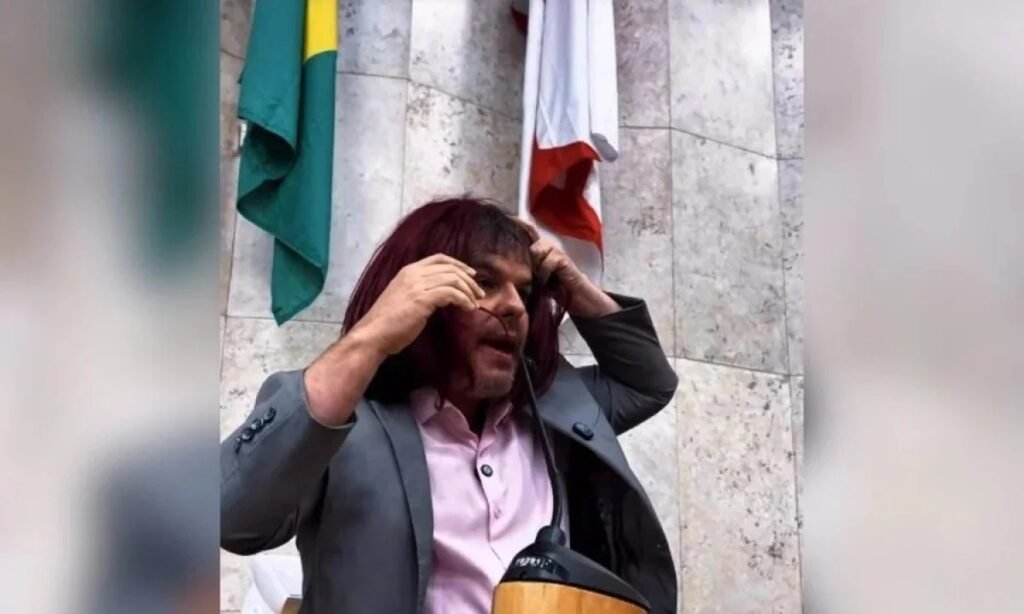 O vereador **Adrilles Jorge**, de São Paulo, protagonizou uma cena inusitada ao usar **batom** e **peruca** durante um discurso no plenário da Câmara Municipal. O ato foi uma forma de criticar um projeto que propõe incluir a **misoginia** entre os crimes de preconceito previstos na **Lei do Racismo**. Segundo a publicação, Adrilles dirigiu-se à colega **Silvia Ferraro**, da **Bancada Feminista** do PSOL, enquanto realizava essa performance. Adrilles argumentou que o projeto possui um "jabuti", termo usado no jargão político para indicar um ponto inserido em uma lei sem relação direta com o tema principal. Ele afirmou que, devido à imprecisão do texto da lei, qualquer pessoa poderia se identificar como mulher, inclusive transexuais, e que isso permitiria a ele debater de igual para igual sem ser criminalizado por ser homem. "Posso contestar a sua ideologia, posso fazer uma brincadeira com a senhora, posso me julgar mulher porque a lei não define o que é uma mulher", declarou o vereador. No entanto, o texto aprovado no Senado não aborda diretamente a definição de mulher, embora mencione a expressão "condição de mulher" como um dos critérios de interpretação da Lei do Racismo. A proposta define **misoginia** como "a conduta que exteriorize ódio ou aversão às mulheres". Além disso, estabelece penas para a injúria misógina, que podem variar de 2 a 5 anos de prisão, além de multa. Também criminaliza condutas que pratiquem, induzam ou incitem discriminação contra mulheres. O projeto foi proposto pela senadora **Ana Paula Lobato** (PSB-MA) e relatado por **Soraya Thronicke** (Podemos-MS), que deu parecer favorável. A senadora Soraya destacou que "o machismo sustenta desigualdades; a misoginia motiva violência; o feminismo busca equidade", enfatizando a importância da proposta no combate à violência de gênero. A reação ao discurso de Adrilles não foi unânime. A vereadora Silvia Ferraro criticou a postura do colega, afirmando que, em meio a uma epidemia de feminicídios, é vergonhoso que um vereador esteja mais preocupado em defender homens misóginos do que em apoiar uma lei que visa proteger mulheres. Segundo a publicação, Ferraro destacou a gravidade da situação atual e a necessidade de medidas legais para combater a violência contra as mulheres. O debate em torno do projeto de lei e a performance de Adrilles Jorge refletem as tensões e divergências sobre como a sociedade deve lidar com questões de gênero e preconceito. A inclusão da misoginia na Lei do Racismo representa um passo significativo no reconhecimento e combate à discriminação de gênero, mas também levanta questões sobre a interpretação e aplicação da lei. A discussão sobre o que constitui misoginia e como ela deve ser penalizada é complexa e envolve diferentes perspectivas sobre gênero, identidade e direitos. O projeto de lei busca estabelecer um marco legal claro para punir atos de ódio e aversão contra mulheres, mas enfrenta desafios na definição e aplicação prática desses conceitos. Em resumo, a ação de Adrilles Jorge e o debate subsequente destacam a importância de um diálogo contínuo e informado sobre gênero e direitos, bem como a necessidade de leis que protejam efetivamente todas as pessoas contra a discriminação e a violência.
