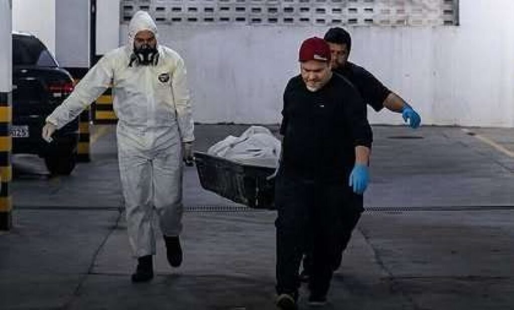 O que aconteceu com João Carmino de Carvalho em Manaus? João Carmino de Carvalho, de 55 anos, foi encontrado morto em seu apartamento em Manaus. Como o corpo de João foi encontrado? O corpo estava em estado avançado de decomposição e foi parcialmente consumido por 11 cães que viviam no local. Por que os cães consumiram o corpo? Os cães ficaram sem acesso a alimentos após o falecimento de João, levando-os a consumir o corpo. Como as autoridades foram alertadas sobre o caso? Moradores vizinhos acionaram as autoridades devido ao odor intenso vindo do apartamento. Quais são as suspeitas iniciais sobre a causa da morte? Indícios preliminares apontam para causas naturais, mas a investigação continua para determinar a causa exata. Qual é o estado dos cães encontrados no apartamento? Os cães estavam soltos dentro do apartamento no momento da descoberta do corpo. O que os vizinhos relataram sobre João Carmino? Os vizinhos relataram que João não era visto há diversos dias antes da descoberta do corpo. Qual é o próximo passo na investigação? A Polícia Civil do Amazonas continua investigando para esclarecer as causas exatas do óbito.