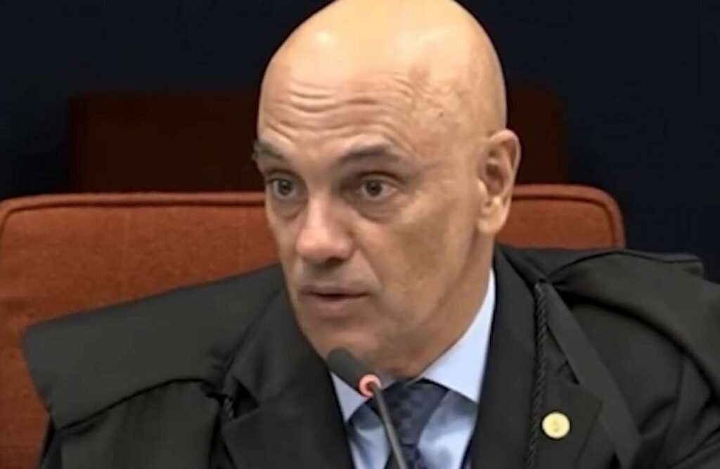 A recente **decisão do ministro Alexandre de Moraes**, do Supremo Tribunal Federal (STF), de conceder **prisão domiciliar ao ex-presidente Jair Bolsonaro** por um período de 90 dias, trouxe à tona uma série de questionamentos e discussões. A decisão, que estabelece regras específicas para visitas, chamou atenção por não incluir um dos filhos do ex-mandatário entre os autorizados. Mas o que exatamente essa decisão implica e por que ela gerou tanta repercussão? Segundo a publicação, o despacho de Moraes determina que Bolsonaro não poderá receber visitas livres durante o período de prisão domiciliar, exceto em casos específicos, como atendimentos médicos, encontros com advogados e visitas de familiares diretos. Entre os filhos autorizados a visitá-lo, o ministro citou nominalmente **Flávio Bolsonaro (PL-RJ)**, **Carlos Bolsonaro (PL-RJ)** e **Jair Renan Bolsonaro (PL-SC)**. As visitas estão permitidas às quartas-feiras e aos sábados, em horários definidos, seguindo regras semelhantes às de unidades prisionais. A ausência do nome de **Eduardo Bolsonaro** na decisão gerou repercussão, já que o deputado federal não foi mencionado em nenhum trecho do documento, ficando fora da lista de familiares autorizados. Por que Eduardo Bolsonaro foi excluído? Na prática, a restrição segue uma determinação anterior do próprio ministro. Em julho de 2025, Moraes havia proibido qualquer contato entre Jair Bolsonaro e Eduardo Bolsonaro, no contexto de um processo que investigava uma suposta tentativa de coação ao STF durante o julgamento relacionado à chamada trama golpista. Embora a **Procuradoria-Geral da República (PGR)** tenha optado por não denunciar o ex-presidente nesse caso específico em setembro de 2025, Eduardo Bolsonaro, conforme o andamento do processo, ainda não foi condenado. Isso significa que as restrições de contato entre pai e filho permanecem em vigor, como parte das medidas cautelares impostas no âmbito das investigações em curso. Por outro lado, a filha mais nova do ex-presidente, **Laura Bolsonaro**, não enfrenta esse tipo de restrição. Por residir com o pai e a ex-primeira-dama **Michelle Bolsonaro** em Brasília, o contato entre eles ocorre de forma contínua, sem necessidade de autorização judicial específica. Isso levanta a questão: por que Laura não está sujeita às mesmas restrições que Eduardo? A resposta pode estar no fato de que Laura não está envolvida em investigações ou processos que justifiquem tais medidas. A decisão de Alexandre de Moraes, ao detalhar as condições da prisão domiciliar, mantém assim limitações específicas de contato, preservando medidas cautelares previamente impostas. Essa abordagem visa garantir que as investigações em curso não sejam comprometidas por possíveis influências externas ou internas. Em meio a esse cenário, surgem também movimentos de apoio a membros da família Bolsonaro. As primeiras camisetas de apoio ao pré-candidato à Presidência da República **Flávio Bolsonaro** já estão disponíveis, destacando a contínua influência política da família no cenário nacional. Em resumo, a decisão de Moraes não apenas estabelece as condições da prisão domiciliar de Jair Bolsonaro, mas também reflete a complexidade das investigações em curso e as medidas cautelares necessárias para garantir a integridade do processo judicial. A exclusão de Eduardo Bolsonaro das visitas autorizadas é um lembrete das implicações legais que ainda pairam sobre ele, enquanto a situação de Laura Bolsonaro destaca as nuances das restrições impostas.