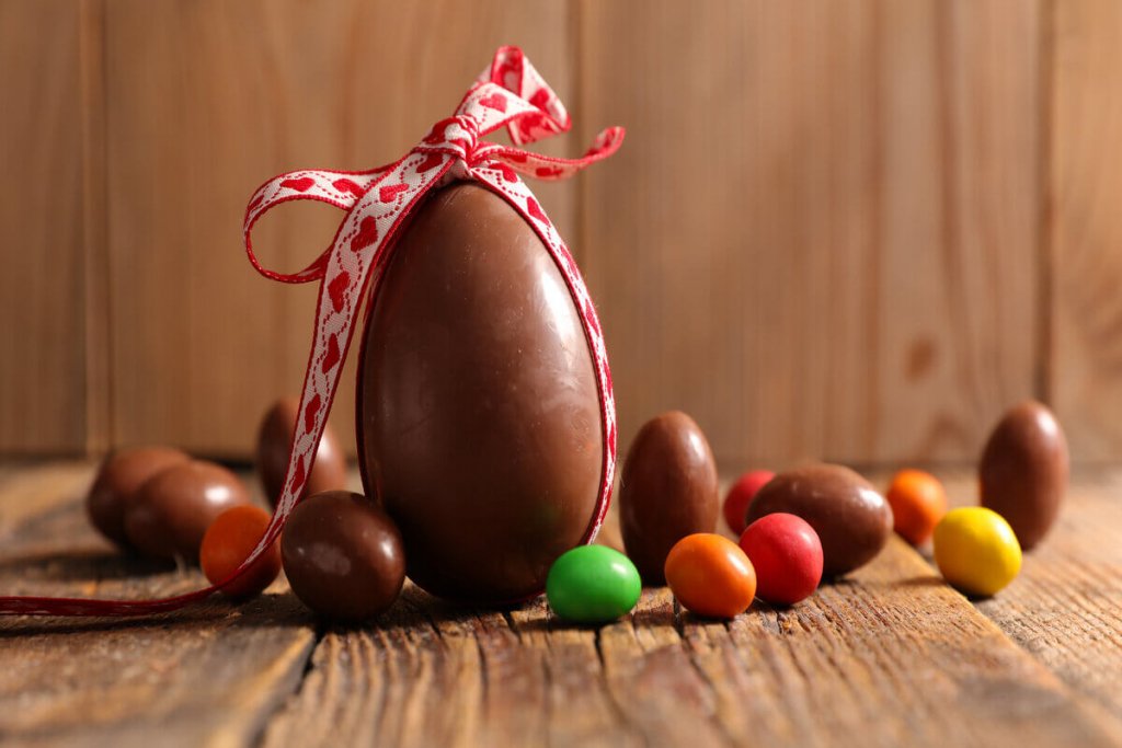 Por que damos ovos de chocolate na Páscoa? A tradição de presentear com ovos de chocolate na Páscoa combina rituais de fertilidade antigos e inovações da confeitaria europeia do século XIX. Qual é a origem dos ovos de Páscoa? Antigas civilizações e cristãos trocavam ovos de galinha decorados para celebrar a primavera e a ressurreição de Cristo. Como o ovo de chocolate se tornou popular? Em 1873, a empresa britânica J.S. Fry & Sons produziu o primeiro ovo de chocolate maciço, transformando o costume em um fenômeno de mercado. Qual é o significado do ovo na Páscoa? O ovo simboliza o renascimento. Pagãos viam nele o ciclo da vida, conceito adaptado pelo cristianismo para ilustrar a ressurreição de Jesus. Como a tradição evoluiu ao longo dos séculos? Confeiteiros franceses e alemães começaram a rechear cascas de ovos com chocolate líquido nos séculos XVIII e XIX, mas o cacau era um luxo. Como a produção em massa influenciou a tradição? Com o avanço das técnicas de solidificação do cacau, a produção em massa de ovos de chocolate se intensificou nas décadas de 1960 e 1970. Por que é importante conhecer a história dos ovos de Páscoa? Compreender a história ajuda a tomar decisões de compra mais conscientes, focando na qualidade e no significado do gesto. Como ressignificar a tradição na prática? Busque chocolates artesanais, com maior teor de cacau e menos aditivos, valorizando pequenos confeiteiros e marcas locais. Qual é o erro comum ao comprar ovos de Páscoa? Ceder à pressão do consumismo e adquirir ovos licenciados com brinquedos, muitas vezes de qualidade inferior e preços altos. Como tornar a troca de ovos mais significativa? Explique o significado histórico ao presentear, criando memórias duradouras e fortalecendo laços afetivos, especialmente com crianças.