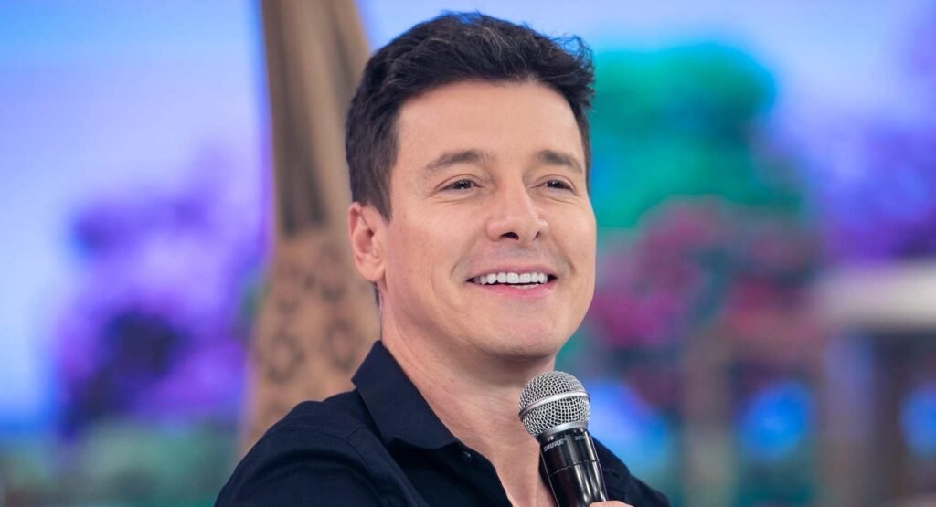 Por que a Globo contratou Rodrigo Faro? A Globo contratou Rodrigo Faro para novos projetos em suas plataformas, visando transformá-lo em peça-chave de um formato inovador que pode gerar milhões em publicidade. Qual é o formato inovador que a Globo planeja? O formato inovador envolve Faro vivendo a rotina de trabalhadores comuns, mostrando o dia a dia de diversas profissões de forma leve e divertida. Como a Globo pretende integrar marcas no projeto? A emissora planeja integrar marcas dentro das histórias vividas por Faro, permitindo que empresas associem seus produtos às profissões mostradas no programa. Quais plataformas exibirão o conteúdo com Rodrigo Faro? O conteúdo será exibido em várias plataformas, incluindo TV aberta, streaming no Globoplay e redes sociais, ampliando o alcance e potencial de faturamento. Qual é o impacto dessa contratação para a Globo? A chegada de Faro reforça a estratégia da Globo de apostar em nomes que fizeram sucesso na Record, sinalizando uma mudança na estratégia da emissora.