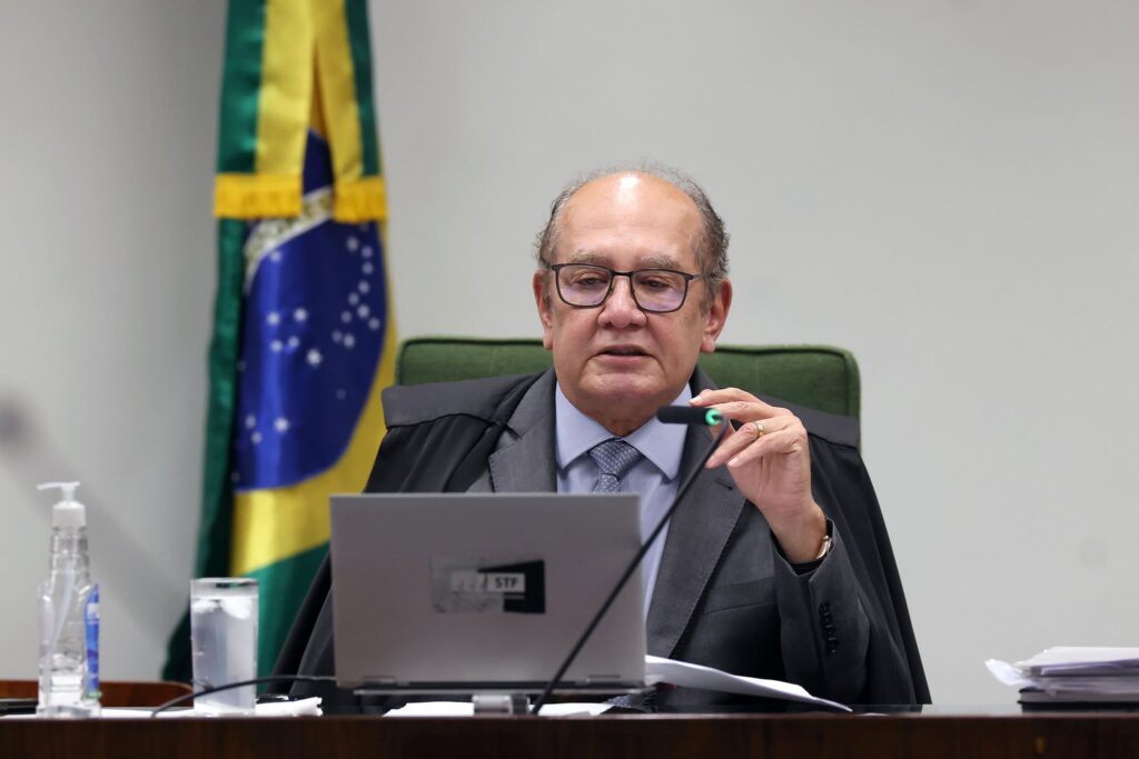O ministro Gilmar Mendes, decano do Supremo Tribunal Federal (**STF**), expressou profunda admiração pelo colega Alexandre de Moraes, destacando que o Brasil tem uma "dívida" com ele. Durante uma sessão no STF, Mendes embargou a voz ao elogiar a atuação de Moraes, ressaltando sua importância no cenário jurídico e político do país. Segundo a publicação do Poder360, essa declaração reflete o reconhecimento do papel crucial de Moraes em momentos decisivos para a nação, especialmente em questões que envolvem a defesa da democracia e do Estado de Direito. Além dos elogios de Gilmar Mendes, o ministro Edson Fachin também destacou a "coragem" de Alexandre de Moraes em suas investigações e na denúncia da tentativa de golpe atribuída ao ex-presidente Jair Bolsonaro. Fachin enfatizou a importância da firmeza e determinação de Moraes em conduzir processos complexos e sensíveis, que exigem não apenas conhecimento jurídico, mas também uma postura ética e corajosa. Segundo o site Poder360, essas qualidades foram fundamentais para enfrentar desafios que ameaçavam a estabilidade institucional do Brasil. A atuação de Alexandre de Moraes no STF tem sido marcada por decisões que visam proteger a ordem constitucional e garantir que a justiça prevaleça em momentos de crise. O reconhecimento público de seus colegas, como Gilmar Mendes e Edson Fachin, reforça a confiança na sua capacidade de lidar com situações delicadas e de grande impacto para o país. Conforme relatado pela fonte, a "dívida" mencionada por Mendes simboliza o apreço e a gratidão por um trabalho que vai além das obrigações judiciais, contribuindo para a manutenção da democracia e dos valores republicanos no Brasil.