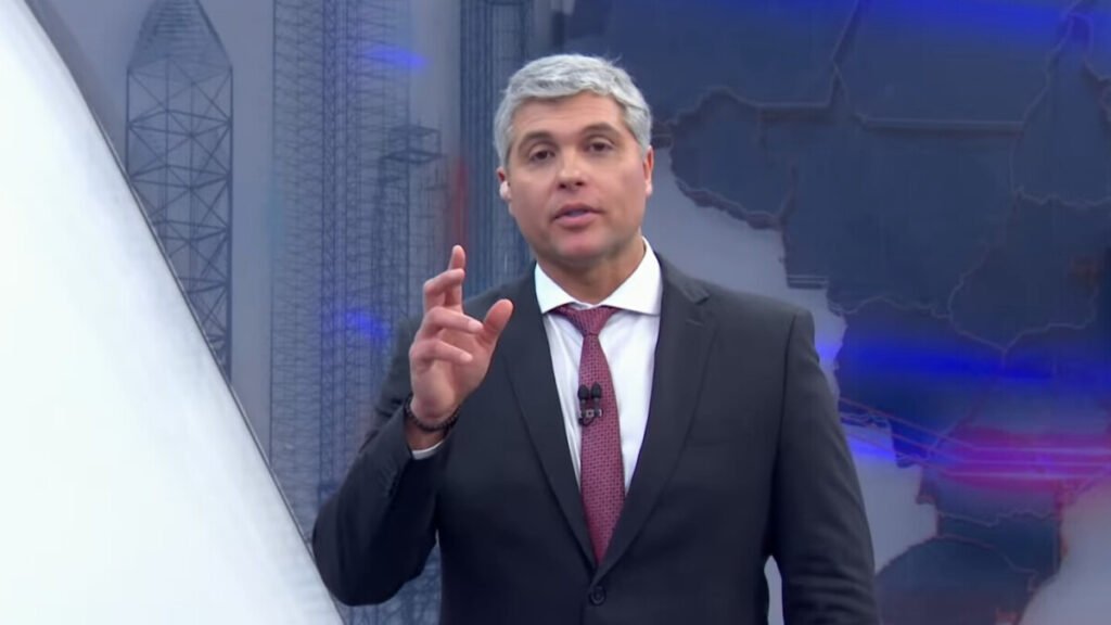 Como Joel Datena iniciou sua carreira na televisão? Joel Datena reconhece que o sobrenome facilitou sua entrada na TV, mas destaca que a permanência dependeu de dedicação e resultados. Ele acredita que muitos não tiveram a mesma oportunidade, mas ele conseguiu mostrar competência e conquistar seu espaço. Quais desafios Joel Datena enfrenta ao substituir seu pai no Brasil Urgente? Joel lida com comparações inevitáveis com seu pai, José Luiz Datena, que comandou o programa por anos. Ele vê isso como uma honra, mas ressalta que o verdadeiro desafio é manter-se relevante e mostrar que tem condições de realizar um bom trabalho. Como Joel Datena responde às críticas sobre ser um "nepobaby"? Joel rebate críticas comuns aos "nepobabies", afirmando que ter uma chance inicial é mais fácil, mas o desafio real é continuar no ar. Ele acredita que a curiosidade do público em saber se ele tem competência é o que realmente importa para sua permanência na televisão. Qual é a visão de Joel Datena sobre a importância da oportunidade na carreira? Joel destaca que, apesar da vantagem inicial pelo sobrenome, a continuidade na carreira depende de mostrar competência e resultados. Ele valoriza a oportunidade que teve, mas enfatiza que o mais importante é provar sua capacidade e conquistar a confiança do público.