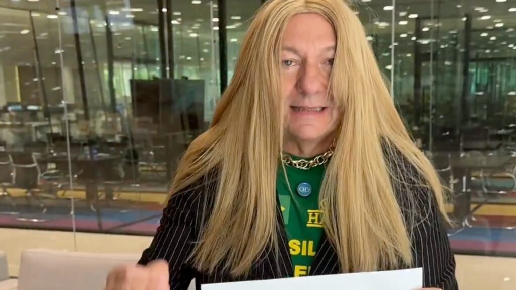 O empresário **Luciano Hang**, conhecido por sua rede de lojas Havan, recentemente chamou a atenção ao colocar uma **peruca loira** em um vídeo. O ato foi uma crítica direcionada à deputada **Erika Hilton**. Segundo a publicação do Poder360, Hang questionou se o uso desse tipo de adereço permitiria a ele "conhecer os verdadeiros problemas de uma mulher". Essa ação remete a um episódio anterior protagonizado por **Nikolas Ferreira** na Câmara dos Deputados, onde ele também utilizou uma peruca para fazer uma crítica semelhante. O gesto de Hang gerou repercussão e debates sobre a representatividade e os desafios enfrentados pelas mulheres na sociedade. Segundo o site, a crítica de Hang parece estar alinhada com uma estratégia de provocar discussão sobre questões de gênero e identidade. A ação de Nikolas Ferreira, que Hang repetiu, havia sido amplamente discutida na mídia e nas redes sociais, destacando a polarização em torno desses temas. A escolha de Hang por repetir esse ato sugere uma tentativa de manter o assunto em evidência, utilizando o humor e a provocação como ferramentas de crítica. A repercussão do ato de Hang também levanta questões sobre o papel de figuras públicas em discussões sociais e políticas. Segundo a publicação, ao adotar uma postura crítica e performática, Hang não apenas expressa sua opinião, mas também influencia o debate público. A escolha de usar uma peruca loira, um símbolo carregado de significados culturais, intensifica a mensagem e provoca reações diversas. Essa estratégia de comunicação, que mistura humor e crítica, reflete uma tendência contemporânea de utilizar plataformas digitais para amplificar vozes e opiniões, gerando engajamento e discussão entre diferentes segmentos da sociedade.