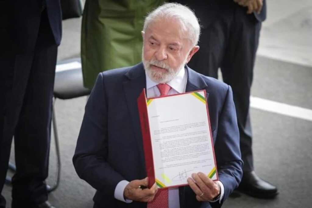 O presidente **Lula** assinou recentemente decretos que regulamentam o **ECA Digital**, estabelecendo novas diretrizes para proteger crianças e adolescentes no ambiente online. Segundo a publicação, essas medidas visam prevenir **violências**, **abusos** e a **exposição indevida** de menores na internet, reforçando a importância de um espaço digital mais seguro para os jovens. A regulamentação do ECA Digital surge em resposta ao crescente uso da internet por crianças e adolescentes, que estão cada vez mais expostos a riscos virtuais. Com a assinatura desses decretos, o governo busca criar um ambiente mais protegido e regulamentado, onde os direitos dos menores sejam priorizados. De acordo com o site, uma das principais mudanças trazidas pelos decretos é a implementação de diretrizes específicas para plataformas digitais. Essas diretrizes exigem que as empresas de tecnologia adotem medidas proativas para identificar e mitigar riscos potenciais à segurança dos jovens usuários. Além disso, as plataformas deverão fornecer ferramentas que permitam aos pais e responsáveis monitorar e controlar o acesso dos menores a conteúdos online. Essa abordagem visa não apenas proteger, mas também educar crianças e adolescentes sobre o uso seguro da internet, promovendo uma cultura de responsabilidade digital. Outro ponto importante destacado pela fonte é a criação de mecanismos de denúncia mais eficazes e acessíveis. Com a nova regulamentação, qualquer violação dos direitos das crianças e adolescentes na internet poderá ser reportada de forma mais ágil, garantindo uma resposta rápida das autoridades competentes. Essa medida é fundamental para assegurar que casos de abuso e exposição indevida sejam tratados com a seriedade e urgência necessárias. A regulamentação do ECA Digital representa um passo significativo na proteção dos jovens no ambiente digital, refletindo o compromisso do governo em garantir um futuro mais seguro para as próximas gerações.