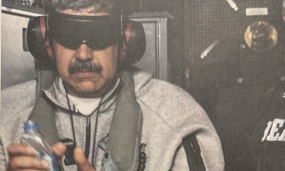 Por que Nicolás Maduro foi detido pelas forças americanas? Maduro foi detido em 3 de janeiro durante uma incursão militar dos EUA, que incluiu bombardeios a Caracas. Ele enfrenta julgamento por acusações de narcotráfico nos Estados Unidos. Como Maduro se comunicou pela primeira vez desde sua prisão? Maduro publicou uma mensagem nas redes sociais afirmando estar "bem", sereno e em oração. Essa foi sua primeira comunicação pública desde a captura. Onde Maduro está preso atualmente? Maduro está em uma prisão de segurança máxima no Brooklyn, junto com sua esposa, Cilia Flores, que foi detida na mesma operação. Qual é a situação de comunicação de Maduro na prisão? Maduro está isolado, sem internet ou jornais, com acesso ao pátio por uma hora diária. Ele pode falar por telefone com a família e advogados por até 15 minutos. Como a mensagem de Maduro foi publicada nas redes sociais? Não está claro se Maduro ditou a mensagem ou apenas aprovou o conteúdo. Ele assinou o texto junto com sua esposa, Cilia Flores. Qual foi a reação de Nicolás Maduro Guerra à prisão de seu pai? Nicolás Maduro Guerra, conhecido como "Nicolasito", afirmou publicamente que seu pai está bem, sereno e até praticando exercícios na prisão. Quem assumiu o poder na Venezuela após a queda de Maduro? Delcy Rodríguez assumiu o poder de forma interina e promoveu mudanças para se aproximar de Washington, desmantelando a estrutura do governo de Maduro. Como Delcy Rodríguez está lidando com a situação de Maduro? Rodríguez não comentou a mensagem de Maduro nem o julgamento em Nova York. Ela pediu uma oração por Maduro e Flores em um ato com evangélicos. Qual foi a resposta do tribunal federal em Nova York ao pedido da defesa de Maduro? O tribunal rejeitou um pedido da defesa para arquivar as acusações contra Maduro, mantendo o processo em andamento. Como a população venezuelana está reagindo à prisão de Maduro? A mensagem de Maduro menciona que ele recebe apoio espiritual através de cartas e orações, indicando que há uma base de apoio entre os venezuelanos. Qual é a importância da Semana Santa para Maduro e a Venezuela? A Semana Santa é uma data de grande importância na Venezuela, um país de maioria católica, e Maduro mencionou estar em oração permanente nesse período. Como a administração de Delcy Rodríguez está se aproximando de Washington? Rodríguez promoveu uma guinada na administração venezuelana, buscando estreitar laços com Washington e desmantelando a estrutura do governo de Maduro. Quais são as acusações enfrentadas por Maduro nos Estados Unidos? Maduro enfrenta acusações de narcotráfico em um tribunal federal em Nova York, onde seu pedido de arquivamento foi rejeitado. Como a mensagem de Maduro foi recebida nas redes sociais? A mensagem foi publicada na rede social X e no Telegram, onde anteriormente havia apenas uma contagem dos dias de "sequestro". Qual é o impacto da prisão de Maduro na política venezuelana? A prisão de Maduro resultou em uma mudança de liderança e uma reestruturação política, com Delcy Rodríguez assumindo o poder e buscando aproximação com os EUA.