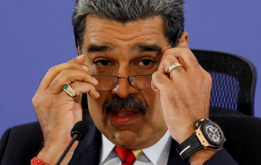 O ex-presidente venezuelano **Nicolás Maduro** comparece novamente a um tribunal em Nova York, em um esforço para anular as acusações de tráfico de drogas que enfrenta. Segundo a publicação, a audiência ocorre em meio a uma disputa geopolítica sobre os honorários advocatícios de Maduro. O advogado de defesa argumenta que os Estados Unidos estão violando os direitos constitucionais de Maduro ao impedir que fundos do governo venezuelano sejam utilizados para cobrir seus custos legais. Por que Maduro está sendo acusado de tráfico de drogas? As acusações contra Maduro surgiram em janeiro, quando ele foi indiciado por supostamente estar envolvido em uma rede de tráfico de drogas. Durante sua primeira aparição no tribunal, Maduro protestou contra sua captura pelas forças militares dos EUA, afirmando: “Não sou culpado. Sou um homem decente, o presidente constitucional do meu país.” Sua esposa, **Cilia Flores**, também se declarou inocente das acusações. Qual é a situação atual de Maduro e Flores? Ambos permanecem detidos em um centro de detenção no Brooklyn e não solicitaram liberação sob fiança. O juiz responsável pelo caso, Alvin Hellerstein, ainda não definiu uma data para o julgamento, mas isso pode ser decidido na audiência atual. Enquanto isso, Maduro e Flores continuam a ter algum apoio na Venezuela, onde murais e outdoors em Caracas exigem seu retorno. Como está a situação política na Venezuela? Apesar de Maduro ainda ter apoio em seu país, ele tem sido gradualmente afastado do governo liderado por **Delcy Rodríguez**, a presidente interina da Venezuela. O partido governante de Maduro permanece no poder, mas sua influência está diminuindo. A Venezuela restabeleceu relações diplomáticas com os Estados Unidos, que haviam sido cortadas em 2019. Naquele ano, os EUA reconheceram o então chefe da Assembleia Nacional, um membro da oposição, como o líder legítimo do país. Quais são as implicações das sanções econômicas dos EUA? Os Estados Unidos aliviaram algumas das sanções econômicas impostas à Venezuela, especialmente aquelas que afetam a crucial indústria petrolífera do país. Além disso, os EUA enviaram um encarregado de negócios para Caracas, sinalizando uma tentativa de normalizar as relações diplomáticas. O que está em jogo para Maduro no tribunal? A audiência em Nova York é crucial para Maduro, pois ele busca anular as acusações de tráfico de drogas. O resultado do julgamento pode ter implicações significativas para sua posição política e seu futuro. A defesa de Maduro está focada em contestar a legalidade das ações dos EUA, argumentando que o bloqueio de fundos para sua defesa é uma violação de seus direitos constitucionais. Como a comunidade internacional está reagindo? A situação de Maduro é acompanhada de perto pela comunidade internacional, que está dividida em relação ao seu apoio. Enquanto alguns países continuam a apoiar Maduro, outros reconhecem a liderança da oposição na Venezuela. A decisão do tribunal pode influenciar as relações internacionais e a política interna da Venezuela. Em resumo, o retorno de Nicolás Maduro ao tribunal dos EUA para contestar as acusações de tráfico de drogas é um evento significativo que pode ter repercussões políticas e legais de longo alcance. O desfecho deste caso pode afetar não apenas o futuro de Maduro, mas também as relações entre a Venezuela e os Estados Unidos.