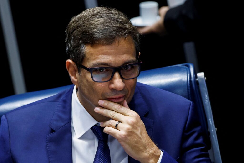 A **presidência do Banco Central (BC)**, sob o comando de **Roberto Campos Neto**, enfrenta um cenário desafiador em meio a investigações sobre possíveis irregularidades envolvendo ex-funcionários da autarquia. A **Controladoria-Geral da União (CGU)** está conduzindo uma investigação para apurar o envolvimento desses ex-funcionários no escândalo relacionado ao **Banco Master**. Campos Neto destacou que a presidência do BC não pode ser responsabilizada por falhas de terceiros, enfatizando a importância de manter a integridade e a confiança na instituição. O que está sendo investigado pela CGU? A CGU está focada em identificar o papel de ex-funcionários do Banco Central no escândalo do Banco Master. A investigação busca esclarecer se houve algum tipo de conluio ou negligência que possa ter facilitado práticas irregulares. Este tipo de investigação é crucial para garantir que as operações financeiras no país sejam conduzidas de maneira ética e transparente. Por que a presidência do BC não pode assumir falhas de terceiros? Campos Neto argumenta que a responsabilidade por ações individuais ou de pequenos grupos não deve recair sobre a liderança da instituição como um todo. Ele ressalta que a estrutura do Banco Central é robusta e possui mecanismos de controle interno para prevenir e identificar irregularidades. No entanto, é impossível garantir que todos os funcionários ajam sempre de acordo com as normas, e é por isso que investigações como a da CGU são essenciais. Qual é a importância de manter a confiança no Banco Central? O Banco Central desempenha um papel vital na estabilidade econômica do país. Ele é responsável por implementar políticas monetárias, regular o sistema financeiro e garantir a estabilidade da moeda. Qualquer dúvida sobre a integridade de suas operações pode ter repercussões significativas na economia, afetando desde a inflação até a confiança dos investidores. Por isso, é fundamental que a instituição mantenha uma imagem de transparência e responsabilidade. Como o Banco Central pode prevenir futuros escândalos? A prevenção de escândalos passa por um fortalecimento contínuo dos mecanismos de controle interno e pela promoção de uma cultura organizacional que valorize a ética e a transparência. Isso inclui treinamentos regulares para os funcionários, auditorias independentes e uma comunicação clara sobre as expectativas de conduta. Além disso, a colaboração com órgãos de fiscalização, como a CGU, é essencial para identificar e corrigir possíveis falhas. Quais são as possíveis consequências para o Banco Master? Se as investigações confirmarem irregularidades, o Banco Master pode enfrentar sanções que vão desde multas até a suspensão de suas operações. Além disso, a reputação do banco pode ser severamente afetada, impactando sua relação com clientes e parceiros. É importante que o banco coopere plenamente com as investigações para mitigar possíveis danos e demonstrar seu compromisso com a conformidade regulatória. Em resumo, o cenário atual destaca a importância de uma governança sólida e de mecanismos de controle eficazes no setor financeiro. A postura de Campos Neto em relação à responsabilidade da presidência do BC reflete a necessidade de distinguir entre falhas individuais e a integridade da instituição como um todo. A confiança no sistema financeiro é um pilar fundamental para a estabilidade econômica, e é essencial que todas as partes envolvidas trabalhem juntas para preservar essa confiança.