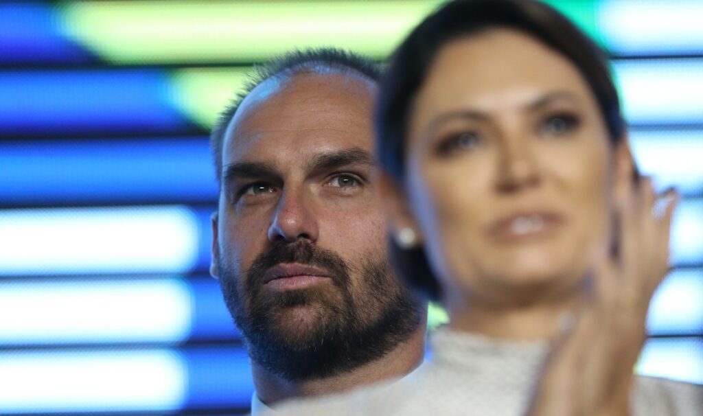 O que motivou Michelle Bolsonaro a publicar uma nota oficial? Michelle Bolsonaro publicou a nota para negar ter recebido ou exibido um vídeo de Eduardo Bolsonaro para Jair Bolsonaro, após determinação do ministro Alexandre de Moraes para que a defesa do ex-presidente se manifestasse sobre possível violação de medidas cautelares. Qual é o conteúdo do vídeo gravado por Eduardo Bolsonaro? O vídeo foi gravado durante a Conferência de Ação Política Conservadora (CPAC) nos EUA. Nele, Eduardo afirma que está gravando para mostrar ao pai e provar que não se pode calar um movimento no Brasil. Por que o vídeo de Eduardo Bolsonaro gerou controvérsia? A controvérsia surgiu porque a gravação foi interpretada como uma possível violação das medidas cautelares impostas a Jair Bolsonaro, que está em prisão domiciliar provisória. Qual foi a reação de Michelle Bolsonaro sobre a interpretação do vídeo? Michelle afirmou que houve uma interpretação equivocada do vídeo e reiterou que as prescrições judiciais estão sendo cumpridas. Ela também disse desconhecer a motivação de Eduardo para a fala. Quais são as medidas cautelares impostas a Jair Bolsonaro? Jair Bolsonaro está em prisão domiciliar provisória em Brasília, após alta hospitalar para tratamento de broncopneumonia. As medidas incluem restrições de comunicação e movimentação. Como Alexandre de Moraes está envolvido no caso? O ministro Alexandre de Moraes determinou que a defesa de Jair Bolsonaro se manifestasse em até 24 horas sobre a possível violação das medidas cautelares relacionadas ao vídeo de Eduardo. Qual é a posição de Michelle sobre o envio de material audiovisual do CPAC? Michelle negou a existência de qualquer material audiovisual enviado pelo CPAC e afirmou que as prescrições judiciais estão sendo cumpridas integralmente. O que Eduardo Bolsonaro quis dizer com "não pode calar um movimento"? Eduardo Bolsonaro sugeriu que o vídeo era uma forma de mostrar resistência e provar que não se pode calar um movimento conservador no Brasil. Qual é a situação atual de Jair Bolsonaro? Jair Bolsonaro está em prisão domiciliar provisória em sua residência em Brasília, cumprindo medidas cautelares impostas pelo STF. O que Michelle sugere sobre a intenção de Eduardo no vídeo? Michelle sugeriu que a intenção de Eduardo não era violar medidas cautelares e que houve uma interpretação equivocada de suas palavras no vídeo. Como a defesa de Jair Bolsonaro deve proceder após a determinação de Moraes? A defesa deve se manifestar em até 24 horas sobre a possível violação das medidas cautelares, conforme determinação do ministro Alexandre de Moraes. Qual é a relação entre Flávio e Eduardo Bolsonaro no contexto do vídeo? Flávio Bolsonaro recorreu a Eduardo para entender uma pergunta em inglês, mas não está diretamente relacionado ao vídeo em questão. Quem é Ronaldo Caiado e qual é sua relevância para o PSD em 2026? Ronaldo Caiado é uma aposta do PSD para a presidência em 2026, mas não está diretamente relacionado ao caso do vídeo de Eduardo Bolsonaro.