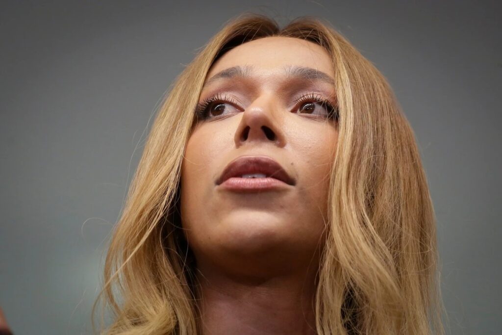 A deputada **Erika Hilton** acionou o Ministério Público contra o governador do Paraná, **Ratinho Jr.**, após um atrito envolvendo casos de estupros em uma escola cívico-militar no estado. Segundo a publicação, a parlamentar questiona a administração estadual sobre a gestão e a segurança nas instituições de ensino militarizadas. O episódio gerou um debate acalorado sobre a eficácia e a segurança das escolas cívico-militares, que têm sido promovidas como um modelo de disciplina e ordem. De acordo com o site, a deputada Erika Hilton expressou preocupação com a proteção dos estudantes e a resposta do governo estadual diante das denúncias de violência sexual. Ela argumenta que é essencial garantir um ambiente seguro e acolhedor para todos os alunos, independentemente do modelo de escola. A parlamentar destacou a necessidade de uma investigação rigorosa para apurar as responsabilidades e implementar medidas preventivas eficazes. O caso trouxe à tona discussões sobre a transparência e a responsabilidade das autoridades na gestão das escolas cívico-militares. O governo do Paraná, liderado por Ratinho Jr., tem defendido o modelo cívico-militar como uma solução para melhorar a qualidade da educação e a segurança nas escolas. No entanto, segundo a publicação, os recentes acontecimentos levantaram questionamentos sobre a real eficácia desse sistema. A deputada Erika Hilton e outros críticos argumentam que é preciso reavaliar as políticas de segurança e proteção dos estudantes, garantindo que os direitos dos alunos sejam respeitados e que casos de violência sejam tratados com a devida seriedade. A situação continua a ser acompanhada de perto por autoridades e pela sociedade civil, que aguardam respostas concretas e ações efetivas por parte do governo estadual.