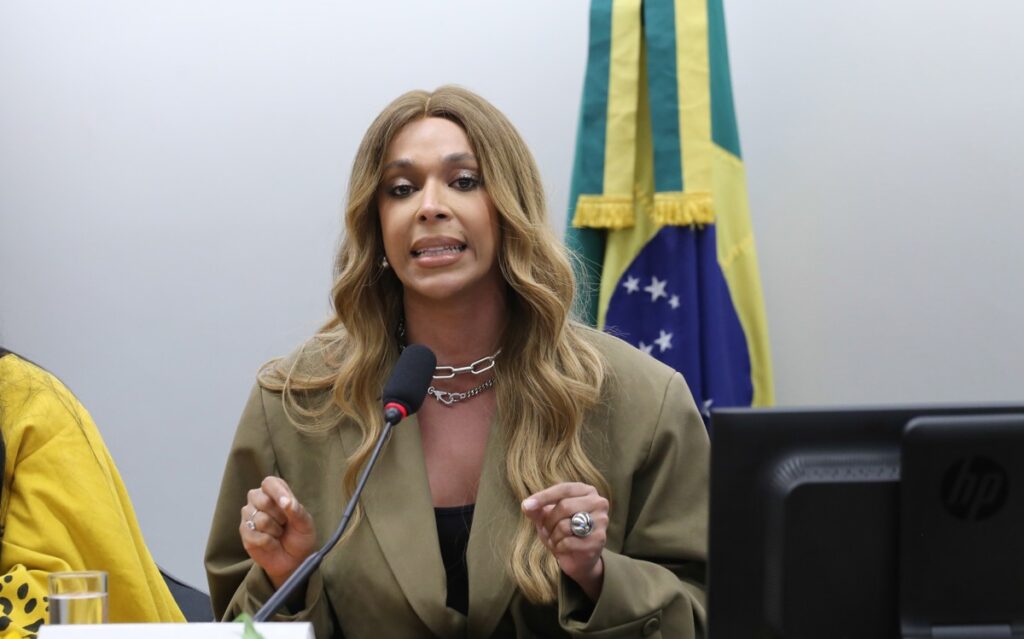 O partido **Novo** acionou o **Conselho de Ética** contra a deputada **Erika Hilton** após ela denunciar o apresentador **Ratinho** por transfobia. A legenda alega que houve "uso abusivo" do mandato por parte da parlamentar. Segundo a publicação, a ação do partido foi motivada pela denúncia feita por Hilton, que considerou que as declarações de Ratinho em seu programa de televisão foram ofensivas à comunidade trans. O partido entende que a atitude da deputada extrapolou suas funções parlamentares, utilizando seu cargo para fins que consideram inadequados. No centro da controvérsia está a acusação de **transfobia** contra o apresentador Ratinho. Erika Hilton, conhecida por sua atuação em defesa dos direitos LGBTQIA+, tomou a iniciativa de denunciar o apresentador após comentários considerados transfóbicos. Segundo o site, a deputada argumentou que as falas de Ratinho não apenas ofenderam indivíduos trans, mas também contribuíram para a perpetuação de preconceitos e discriminação. A ação de Hilton foi vista por seus apoiadores como uma defesa necessária dos direitos humanos, enquanto seus críticos, incluindo o partido Novo, a consideraram um uso indevido de sua posição parlamentar. O partido Novo, ao acionar o Conselho de Ética, busca uma avaliação sobre a conduta de Erika Hilton, questionando se suas ações foram apropriadas dentro do contexto de suas responsabilidades como deputada. Segundo a publicação, o partido acredita que a denúncia contra Ratinho foi uma tentativa de censura e uma violação da liberdade de expressão. Este caso levanta questões importantes sobre os limites da atuação parlamentar e o equilíbrio entre a defesa dos direitos das minorias e a liberdade de expressão. A decisão do Conselho de Ética poderá estabelecer precedentes sobre como tais situações serão tratadas no futuro, refletindo sobre o papel dos parlamentares na defesa de direitos e na utilização de seus mandatos.