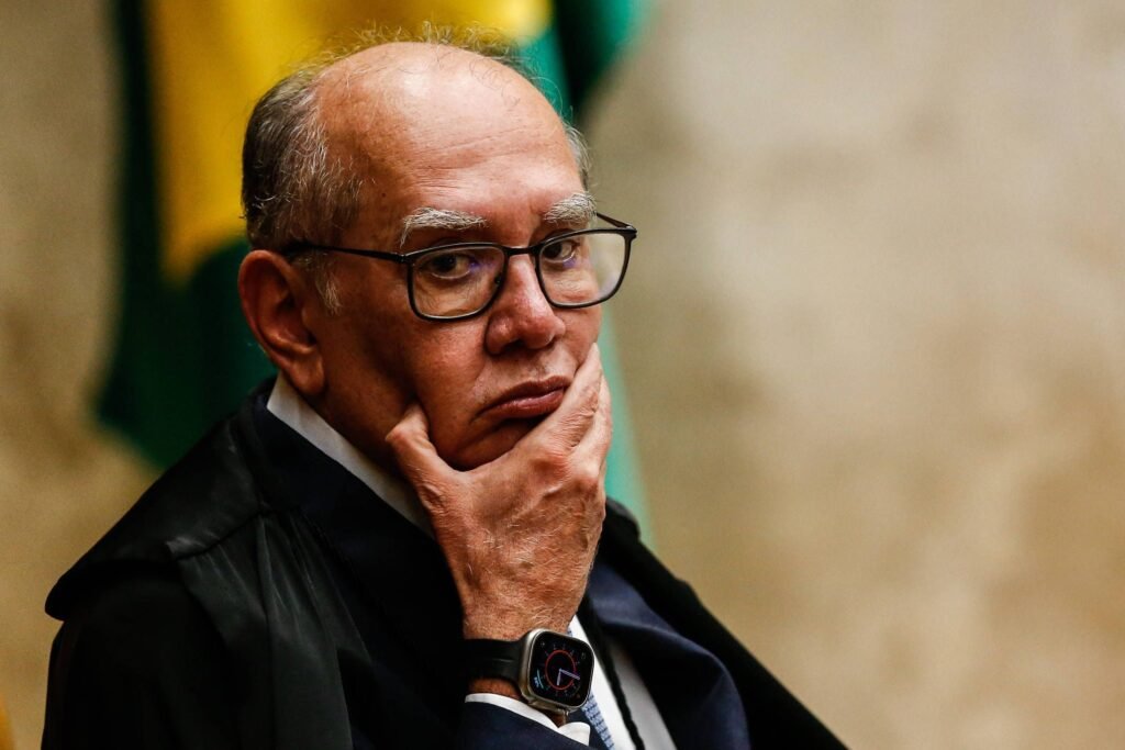Por que os parlamentares de oposição apresentaram uma notícia-crime contra Gilmar Mendes? Os parlamentares alegam que Gilmar Mendes cometeu calúnia e difamação ao acusar membros da CPI de vazarem informações sigilosas sem especificar nomes. Qual foi a reação de Gilmar Mendes durante a sessão no STF? Gilmar Mendes afirmou que membros da CPI Mista praticaram condutas criminosas, chamando-as de "abomináveis" e com "falta de escrúpulo". Quem são os parlamentares envolvidos na notícia-crime contra Gilmar Mendes? Os deputados Sóstenes Cavalcante, Hélio Lopes, Evair de Melo, Luiz Lima, Marcel Van Hattem, Coronel Chrisóstomo e os senadores Magno Malta e Eduardo Girão. Qual é o argumento dos parlamentares sobre a imunidade funcional? Eles defendem que a imunidade funcional não deve proteger condutas que visem a execração pública de membros de outros Poderes sem individualização de crimes. Como foi o acesso aos documentos da CPI Mista do INSS? Inicialmente, os documentos podiam ser acessados por servidores nos gabinetes, mas após vazamentos, foram enviados a uma sala-cofre no Senado. O que aconteceu após a chegada dos novos documentos à sala-cofre? Representantes da oposição, como Evair de Melo, deram coletivas de imprensa revelando algumas informações sobre os documentos. Quais informações estavam nos documentos vazados? Os documentos incluíam dados dos celulares de Daniel Vorcaro, dono do Banco Master. Qual foi a justificativa de uma parlamentar de oposição sobre a divulgação de informações? Ela argumentou que a divulgação não seria proibida pelo sigilo, apenas o compartilhamento dos próprios documentos. Qual foi a decisão dos ministros do STF sobre a CPI? Os ministros decidiram encerrar os trabalhos da CPI, contrariando a ordem de André Mendonça de prorrogar a comissão. Qual é o prazo para a CPI aprovar seu relatório final? O colegiado tem até sábado (28) para aprovar o relatório final. Quais são as possíveis consequências das acusações de Gilmar Mendes? As acusações podem gerar tensões entre os Poderes e questionamentos sobre a conduta de membros da CPI. Como a notícia-crime pode impactar a imagem de Gilmar Mendes? Pode gerar debates sobre a responsabilidade de ministros do STF ao fazerem acusações públicas sem provas concretas. Qual é a importância de proteger informações sigilosas em CPIs? Proteger informações sigilosas é crucial para garantir a integridade das investigações e a confiança pública no processo. Como a opinião pública pode ser influenciada por este caso? A opinião pública pode ser dividida, com debates sobre a transparência e a responsabilidade de autoridades públicas. Quais são os próximos passos após a apresentação da notícia-crime? A PGR deve analisar a notícia-crime e decidir se há elementos suficientes para investigar Gilmar Mendes. Como este caso reflete a relação entre os Poderes no Brasil? O caso evidencia tensões e desafios na relação entre o Judiciário e o Legislativo, especialmente em contextos de investigação.