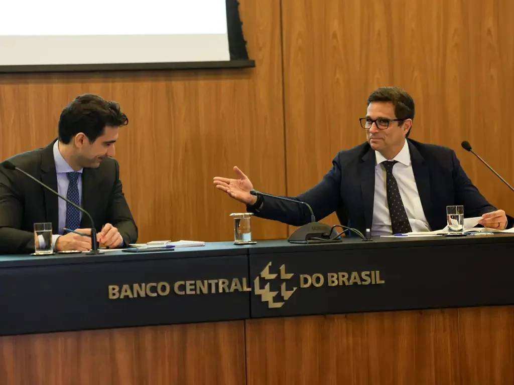 A **Polícia Federal** está investigando possíveis omissões do **Banco Central** durante as gestões de **Gabriel Galípolo** e **Roberto Campos Neto** no caso do **Banco Master**. Segundo a CNN, a investigação busca determinar se ambos os presidentes do BC tinham conhecimento de irregularidades envolvendo servidores públicos e o banco de **Daniel Vorcaro**. A atuação de **Paulo Sérgio Souza** e **Bellini Santana**, servidores que supostamente favoreciam Vorcaro, é um dos principais focos da investigação. Quem são os principais envolvidos na investigação? Segundo a publicação, os principais envolvidos são Gabriel Galípolo, atual presidente do Banco Central, e Roberto Campos Neto, que liderou a instituição entre 2019 e 2024. Ambos estão sob escrutínio por supostas omissões relacionadas ao caso do Banco Master. Além deles, os servidores Paulo Sérgio Souza e Bellini Santana são citados por atuarem em prol dos interesses de Vorcaro dentro do BC. Qual é o papel de Daniel Vorcaro no caso? Daniel Vorcaro é apontado como figura central no esquema investigado. Durante a gestão de Campos Neto, Vorcaro negociou a compra de três instituições financeiras, levantando suspeitas de fraude. A investigação busca entender se houve conivência ou omissão por parte dos líderes do Banco Central em relação a essas atividades. Por que a investigação foi iniciada? A investigação foi motivada pela atuação suspeita de servidores do Banco Central, que teriam favorecido Vorcaro. A operação "Sem Desconto", conduzida pela Polícia Federal e pela CGU, revelou falhas de fiscalização e controle no sistema financeiro, especialmente no crédito consignado voltado a aposentados e pensionistas do INSS. Estima-se que mais de 250 mil contratos, somando cerca de R$ 2 bilhões, estejam sob suspeita. Qual é a posição dos envolvidos? Roberto Campos Neto nega qualquer irregularidade ou omissão durante sua gestão. Ele afirma que não fez vista grossa para os indícios de fraude envolvendo Vorcaro. Gabriel Galípolo, por sua vez, declarou que o Banco Central está passando por um "processo de luto" devido à identificação de servidores possivelmente cooptados pelo esquema. Ele enfatizou a importância da ética para os servidores da instituição e afirmou que o BC respondeu de maneira pronta e correta. O que a CPMI do INSS tem a ver com o caso? A Comissão Parlamentar Mista de Inquérito (CPMI) do INSS aprovou convites para que Galípolo e Campos Neto sejam ouvidos sobre o caso. Segundo o senador Carlos Viana, presidente da CPMI, a expansão das irregularidades no crédito consignado ocorreu em meio a falhas de fiscalização durante ambas as gestões. A CPMI busca esclarecer o papel do Banco Central na supervisão dessas operações. Quais são as próximas etapas da investigação? A investigação está em andamento, com a Polícia Federal e a CGU analisando documentos e depoimentos para determinar a extensão das irregularidades e a responsabilidade dos envolvidos. A participação de Galípolo e Campos Neto na CPMI do INSS será um passo importante para esclarecer os fatos e avaliar possíveis omissões ou conivências. Em resumo, a investigação da Polícia Federal sobre possíveis omissões do Banco Central no caso do Banco Master envolve figuras de destaque como Gabriel Galípolo e Roberto Campos Neto. A atuação de servidores públicos em favor de Daniel Vorcaro é um dos principais focos, com a CPMI do INSS buscando esclarecer o papel do BC na supervisão do sistema financeiro durante as gestões investigadas.