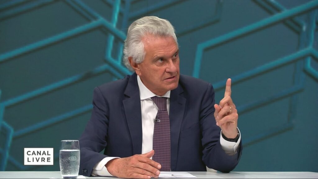 Quem é Ronaldo Caiado e por que ele está em destaque? Ronaldo Caiado é o governador de Goiás e foi escolhido pelo PSD como pré-candidato à Presidência, buscando ser uma alternativa à polarização política entre Lula e Flávio Bolsonaro. Qual é a formação profissional de Ronaldo Caiado? Caiado é médico ortopedista e professor, além de ter uma longa carreira política, incluindo mandatos como deputado federal e senador. Por que o PSD escolheu Caiado como pré-candidato? O PSD busca oferecer uma terceira via na polarização política atual, apresentando Caiado como uma opção independente, embora mais alinhada à direita. Como Caiado se posiciona politicamente? Ele se intitula como "via independente", mas está mais alinhado à direita do que ao centro, sendo um adversário histórico do PT. Qual é a relação de Caiado com o setor rural? Caiado vem de uma família de produtores rurais e já presidiu a União Democrática Ruralista, defendendo interesses dos grandes proprietários rurais. Como foi a trajetória política de Caiado antes de ser governador? Ele foi deputado federal por cinco mandatos e senador, deixando o Senado para assumir o governo de Goiás em 2019. Qual foi o desempenho de Caiado nas eleições presidenciais de 1989? Caiado se candidatou à Presidência em 1989, mas obteve menos de 1% dos votos, ficando em décimo primeiro lugar. Qual foi a postura de Caiado no segundo turno das eleições de 1989? No segundo turno, Caiado apoiou o ex-presidente Fernando Collor, que acabou vencendo a eleição. Como Caiado é visto em relação ao PT? Ele se considera o mais antigo e longínquo adversário do PT, tendo enfrentado Lula nas eleições de 1989. Qual é a importância da família de Caiado na política de Goiás? A família de Caiado tem forte presença na política de Goiás desde o século XIX, influenciando a política local por gerações. Como Caiado se destacou no Congresso Nacional? Em 2013, ele foi um dos líderes mais ativos da Bancada Ruralista, defendendo interesses do agronegócio no Congresso. Por que as buscas por Caiado aumentaram recentemente? O anúncio de sua pré-candidatura à Presidência pelo PSD gerou um aumento significativo nas buscas pelo seu nome. Qual é a estratégia do PSD ao lançar Caiado como pré-candidato? O PSD busca romper a polarização política, oferecendo Caiado como uma alternativa viável e independente. Como Caiado se diferencia de outros candidatos? Ele se apresenta como uma "via independente", buscando atrair eleitores insatisfeitos com a polarização entre Lula e Bolsonaro. Qual é o impacto da pré-candidatura de Caiado no cenário político? A entrada de Caiado na corrida presidencial pode alterar o equilíbrio político, oferecendo uma nova opção aos eleitores. Como Caiado pretende conquistar o eleitorado? Ele aposta em sua experiência política e em seu histórico como adversário do PT para atrair eleitores de direita e centro-direita. Qual é a expectativa para a campanha de Caiado? Espera-se que Caiado foque em temas como agronegócio e economia, buscando se diferenciar dos outros candidatos. Como a experiência de Caiado como governador pode influenciar sua campanha? Sua gestão em Goiás pode ser usada como exemplo de liderança e competência administrativa para atrair eleitores. Quais são os desafios de Caiado na corrida presidencial? Ele precisa se destacar em um cenário polarizado e convencer eleitores de que é uma alternativa viável e independente. Como a história política de Caiado pode impactar sua candidatura? Seu longo histórico político pode ser visto como experiência valiosa, mas também pode ser alvo de críticas por opositores.