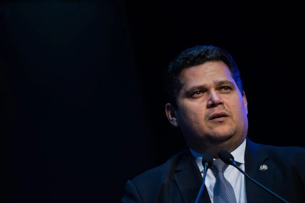 Quem é o relator da CPMI do INSS e o que ele pediu? O deputado Alfredo Gaspar (PL-AL) apresentou o relatório final da CPMI do INSS, pedindo o indiciamento de Paulo Augusto de Araújo Boudens, ex-assessor de Davi Alcolumbre, por envolvimento em fraudes na Previdência. Qual é a acusação contra Paulo Boudens? Boudens é acusado de receber R$ 3 milhões de uma empresa envolvida em fraudes no INSS, atuando como "operador de influência política de alto nível" e facilitando a dissimulação da origem dos valores. Quem é o "Careca do INSS" e qual seu papel? Antônio Carlos Camilo Antunes, conhecido como "Careca do INSS", é apontado como lobista que usou uma empresa para dissimular a origem de valores ilícitos, conectando-se a redes de lavagem de dinheiro. Por que a CPMI focou em Boudens? Boudens entrou na mira da CPMI em outubro passado, quando foi analisado um pedido de quebra de seus sigilos bancário e fiscal, barrado por articulação governista. Ele é visto como peça-chave no esquema. Quais crimes Boudens pode ter cometido? O relatório sugere o indiciamento de Boudens por organização criminosa, lavagem de dinheiro, corrupção passiva e advocacia administrativa, devido ao seu papel no esquema de fraudes no INSS. Qual era o papel de Boudens no Senado? Boudens foi chefe de gabinete de Alcolumbre e assessor parlamentar, cargos que lhe conferiam trânsito político privilegiado, facilitando sua atuação no esquema de fraudes. Como Boudens ajudou a dissimular recursos? Ele teria recebido valores que eram pulverizados por empresas de consultoria antes de chegar às suas contas, ajudando a dissimular a origem ilícita dos recursos extraídos de aposentados. O que acontece se o relatório for aprovado? Se aprovado, o relatório será encaminhado a órgãos como o Ministério Público Federal e a AGU, que decidirão sobre a apresentação de denúncias com base nas conclusões da CPMI. Qual é a importância do indiciamento de Boudens? O indiciamento de Boudens é crucial para desmantelar a rede de fraudes no INSS, responsabilizando penalmente aqueles que integraram e se beneficiaram do esquema. Como o esquema afetava aposentados? O esquema envolvia descontos indevidos nos sistemas do INSS, prejudicando aposentados que viam seus benefícios reduzidos por fraudes orquestradas por uma rede de corrupção. Qual é o próximo passo da CPMI? A CPMI discute o parecer final de Gaspar e, se aprovado, o relatório será enviado a órgãos competentes para avaliação e possível apresentação de denúncias. Como a base governista influenciou a CPMI? A base governista barrou a quebra de sigilos de Boudens, dificultando a investigação, mas a CPMI conseguiu avançar e apresentar o relatório final com pedidos de indiciamento. O que o relatório revela sobre a influência política? O relatório destaca que Boudens usava sua posição para integrar ativos ilícitos à esfera política, garantindo proveito econômico para a organização criminosa. Qual é o impacto do relatório na política? O relatório pode abalar a confiança nas instituições políticas, destacando a necessidade de maior transparência e responsabilidade para combater a corrupção. Como a sociedade pode acompanhar o caso? A sociedade deve se manter informada sobre o andamento do caso, cobrando transparência e justiça para que os responsáveis sejam devidamente punidos.