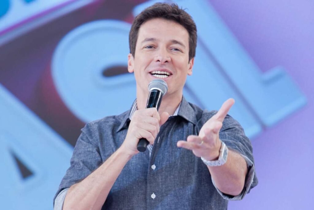 Por que Rodrigo Faro voltou para a Globo após 18 anos? Rodrigo Faro retornou à Globo após 18 anos para apresentar um novo programa na Globoplay, marcando sua reaproximação com a emissora. Qual será o novo projeto de Rodrigo Faro na Globoplay? Ele comandará um programa inédito, ainda em fase de desenvolvimento, com estreia prevista para este ano. Quando Rodrigo Faro começará a aparecer na TV aberta? A volta à TV aberta não será imediata, seguindo a estratégia de "pedágio" no streaming, como ocorreu com Ticiane Pinheiro. O que Faro fez na Globo antes de sair em 2008? Antes de sair, ele atuava em novelas como "O Cravo e a Rosa" e "Chocolate com Pimenta". Como foi a trajetória de Faro na Record? Na Record, Faro consolidou-se como apresentador de auditório com "O Melhor do Brasil" e "Hora do Faro" por 16 anos. Qual é o outro projeto de Faro na Globo em 2026? "Faro Fora do Ar", uma série onde ele vivenciará profissões inusitadas, será exibida no Multishow e na TV aberta. Como foi a reaproximação de Faro com a Globo? A reaproximação começou após sua saída da Record em 2024 e se intensificou com sua participação na "Dança dos Famosos" em 2025. O que Faro comentou sobre seu retorno à TV? Horas antes do anúncio, Faro brincou no Instagram: "O Brasil quer que eu volte para a televisão? É, acho que está na hora de voltar".