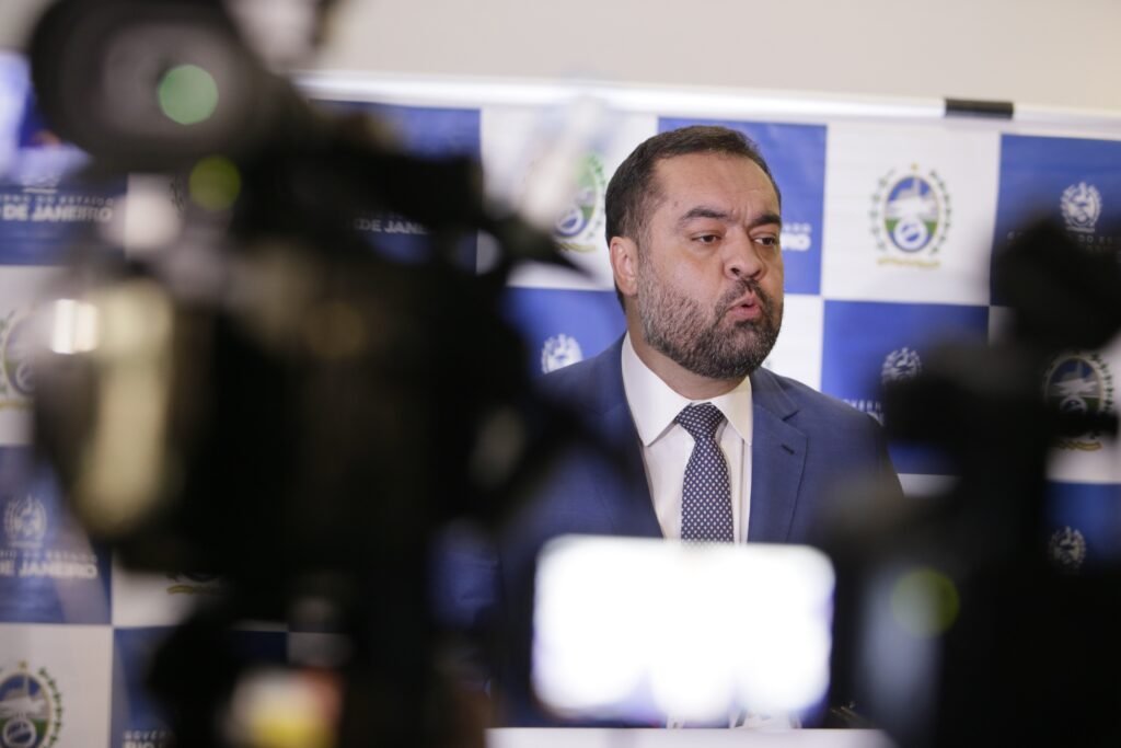 O **Tribunal Superior Eleitoral (TSE)** confirmou que a eleição para o governo do Rio de Janeiro, após a renúncia de Cláudio Castro, será **indireta**. Esta decisão foi comunicada ao governador em exercício, desembargador Ricardo Couto, que havia questionado a Corte sobre o formato do pleito. Segundo a publicação, a eleição será conduzida pela **Assembleia Legislativa do Rio (Alerj)**, seguindo precedentes do **Supremo Tribunal Federal (STF)** que permitem aos estados definir regras para eleições em casos de "dupla vacância" por razões não eleitorais. Por que a eleição será indireta? A eleição indireta foi escolhida porque não há vice-governador e a renúncia de Castro não foi motivada por cassação, mas sim por uma tentativa de evitar essa punição. Segundo a publicação, Castro foi condenado por abuso de poder político e econômico, mas a renúncia impediu a cassação de seu diploma. No entanto, ele foi declarado inelegível por oito anos, até 2030, o que impede sua candidatura ao Senado. Como será o processo de eleição indireta? A eleição indireta será realizada pela Alerj, com os deputados estaduais votando para escolher o novo governador. Inicialmente, o texto aprovado pelos deputados previa voto aberto e um prazo de desincompatibilização de 24 horas após a dupla vacância. Contudo, após questionamento do PSD ao STF, o ministro Luiz Fux determinou que a eleição deve ocorrer com voto secreto e que o prazo de desincompatibilização deve ser de seis meses antes do pleito, conforme as regras das eleições gerais. Quais são as implicações da renúncia de Castro? A renúncia de Cláudio Castro gerou um cenário inédito na linha sucessória do governo do Rio. Sem vice-governador, devido à indicação de Thiago Pampolha ao Tribunal de Contas do Estado do Rio (TCE-RJ), e sem presidente da Alerj, já que Rodrigo Bacellar foi afastado por investigação de obstrução de Justiça, a situação se tornou complexa. Bacellar, inclusive, teve seu mandato cassado pelo TSE no mesmo julgamento que condenou Castro. Qual é a posição do TSE e do STF sobre a eleição indireta? O TSE, por maioria, considerou prejudicada a cassação do diploma de Castro devido à sua renúncia. Já o STF, através do voto do ministro Luiz Fux, afirmou que os estados têm competência legislativa para regulamentar eleições indiretas em casos de dupla vacância por causas não eleitorais. Essa posição reforça a autonomia dos estados em definir suas regras eleitorais em situações específicas. Quais são os próximos passos? O governador em exercício, Ricardo Couto, afirmou que adotará cautela e adiará a convocação da eleição até que todas as dúvidas sobre o modelo sejam esclarecidas. Ele destacou a importância de evitar questionamentos futuros e mencionou a possibilidade de correção na certidão do julgamento para retirar menções equivocadas sobre eleição direta. Em resumo, a eleição indireta para o governo do Rio de Janeiro, após a renúncia de Cláudio Castro, segue um caminho complexo devido à ausência de sucessores diretos e às decisões judiciais que moldam o processo. A situação destaca a importância de uma regulamentação clara e a necessidade de alinhamento entre as decisões do TSE e do STF para garantir a legitimidade do pleito.