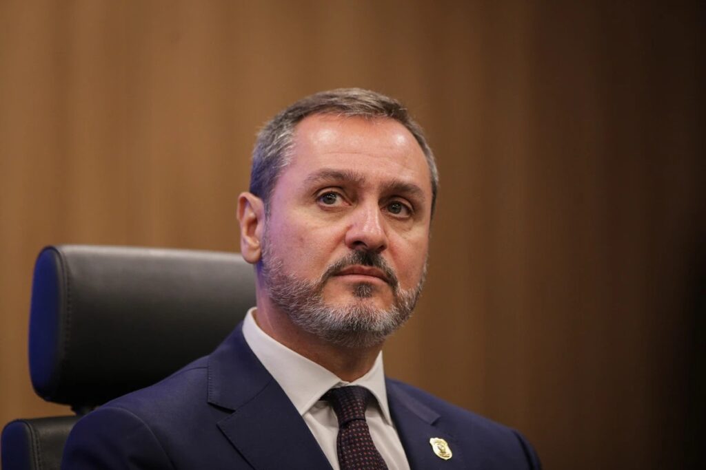 O diretor-geral da **Polícia Federal (PF)** manifestou-se firmemente em relação às críticas direcionadas à corporação após a **Comissão Parlamentar Mista de Inquérito (CPMI) do INSS** ter obtido acesso a vídeos íntimos de **Daniel Vorcaro** e fotos de políticos. Segundo a publicação, ele enfatizou que "fofocas e vida privada de terceiros não interessam" à PF, destacando a importância de manter o foco nas investigações relevantes e no cumprimento das responsabilidades institucionais. Esta declaração surge em um momento de intensa discussão sobre a privacidade e a ética no manuseio de informações sensíveis por parte das autoridades. A reação do diretor-geral da PF reflete uma preocupação com a integridade e a imagem da instituição, que pode ser comprometida por envolvimentos em questões de caráter pessoal e não relacionadas diretamente às suas funções. Segundo o site, a divulgação de conteúdos íntimos de figuras públicas como Daniel Vorcaro e políticos levanta questões sobre os limites da atuação da PF e a necessidade de proteger a privacidade dos indivíduos, mesmo quando estão sob investigação. A declaração do chefe da PF visa reafirmar o compromisso da corporação com a legalidade e a ética, evitando que a instituição seja associada a práticas que possam ser interpretadas como invasivas ou sensacionalistas. Além disso, a situação destaca a importância de um debate mais amplo sobre a proteção de dados e a privacidade no contexto das investigações policiais. A obtenção e o uso de informações pessoais devem ser conduzidos com rigor e responsabilidade, garantindo que os direitos dos cidadãos sejam respeitados. Segundo a publicação, a postura do diretor-geral da PF busca assegurar que a corporação mantenha seu foco em questões de interesse público e na execução de suas funções de forma transparente e responsável, evitando que questões pessoais desviem a atenção dos objetivos principais das investigações.