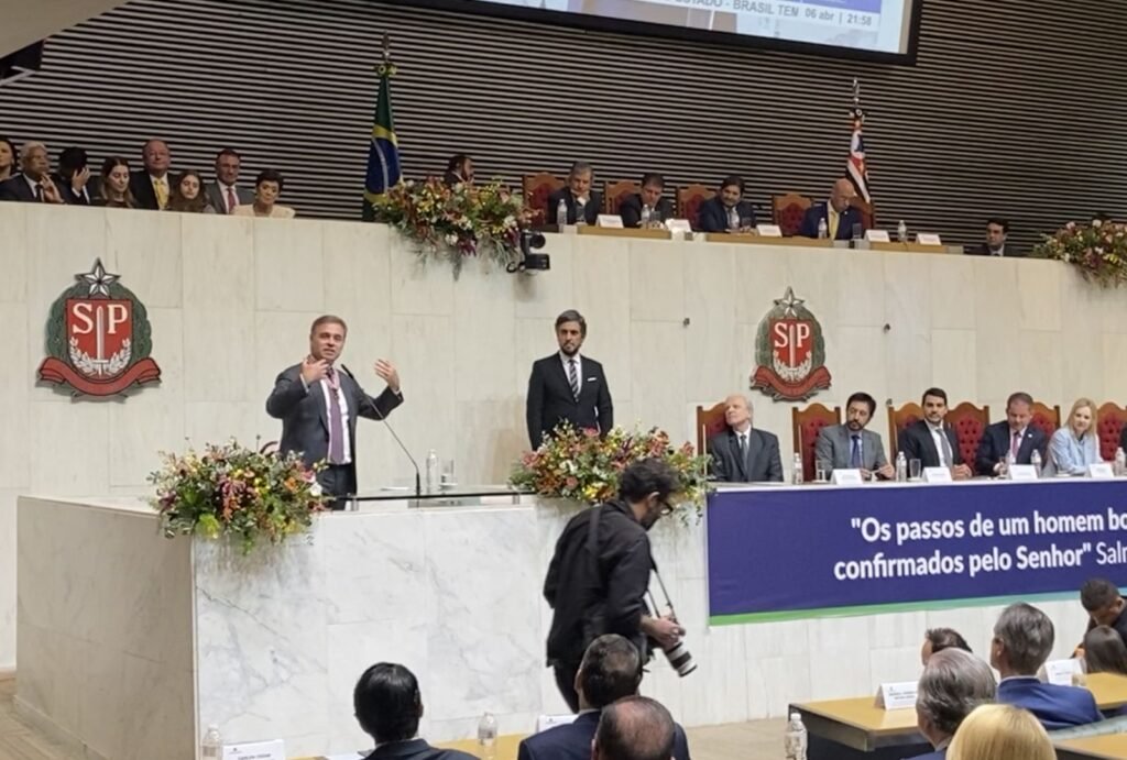 Foi uma homenagem política, religiosa e simbólica ao mesmo tempo — e isso ficou evidente desde os primeiros momentos da cerimônia em São Paulo. Mas o que exatamente aconteceu com **André Mendonça**? O ministro do **Supremo Tribunal Federal** recebeu o **Colar da Honra ao Mérito Legislativo** na **Assembleia Legislativa de São Paulo** na segunda-feira, **6 de abril de 2026**, em um evento marcado por oração, louvor e referências bíblicas. Quem esteve ao lado dele nessa homenagem? Entre os presentes, estava o governador de São Paulo, **Tarcísio de Freitas**, que participou da cerimônia e fez um discurso com forte tom religioso. A presença dele deu ainda mais peso político ao ato, que reuniu autoridades e lideranças evangélicas em torno do ministro. E por que a cerimônia chamou tanta atenção? Porque não se tratou apenas da entrega de uma medalha. A homenagem teve características claramente religiosas, algo reforçado pelo perfil de **Mendonça**, que é **pastor presbiteriano**. A sessão foi aberta com uma oração feita pelo pastor **Arival Dias Casimiro**, e, ao longo do evento, o grupo de louvor **Ad Brás de São Bernardo** cantou duas vezes. Houve outras manifestações religiosas durante a solenidade? Sim. O presidente da **Assembleia de Deus**, bispo **Samuel Ferreira**, participou por vídeo e dirigiu palavras ao ministro. Em sua fala, afirmou: “**Suas sentenças são apresentadas para Deus antes de serem dadas**”. A frase resumiu o tom adotado por parte dos participantes, que associaram a atuação pública de Mendonça à sua fé. E como foi o momento da entrega da homenagem? Enquanto o ministro recebia a medalha, a pastora **Silvana Santos** entregou um buquê de flores à mulher dele, **Janey Mendonça**. O gesto ampliou o caráter cerimonial da ocasião e reforçou o ambiente de reverência construído ao longo do evento. Quem propôs a homenagem? A iniciativa partiu do deputado estadual **Oseias de Madureira**, do **PL**, que também é pastor evangélico. Esse detalhe ajuda a entender o formato da sessão e o perfil dos participantes que conduziram a homenagem. O que disse o próprio André Mendonça? Ao encerrar seu discurso, o ministro afirmou: “**Que Deus me ajude e que Deus nos ajude a sermos homens públicos e, no meu caso, magistrados imparciais e íntegros**”. A declaração uniu duas dimensões que atravessaram toda a cerimônia: a religiosa e a institucional. E qual foi a fala de Tarcísio de Freitas? O governador, pré-candidato à reeleição em São Paulo, disse que Deus encheu o ministro de “**dons espirituais**”. Em seguida, declarou: “**Aquilo que você recebeu veio pela Graça e pela Misericórdia. Deus deu uns para apóstolos, outros para profetas, outros para evangelistas, outros para pastores e doutores. E Deus te encheu de dons espirituais**”. Por que o nome de Mendonça tem ganhado destaque além dessa homenagem? Porque ele é relator, no STF, dos casos **Master** e **INSS**, apontados como os 2 maiores escândalos em andamento no país, segundo a descrição da reportagem. Indicado ao Supremo por **Jair Bolsonaro**, o ministro também tem sido citado por apoiadores do ex-presidente, que usam decisões dele nesses casos para criticar **Alexandre de Moraes** e o presidente **Luiz Inácio Lula da Silva**. Quais decisões recentes reforçaram essa visibilidade? Mendonça determinou a prisão do ex-banqueiro **Daniel Vorcaro**. Também autorizou a quebra dos sigilos bancário e fiscal de **Fábio Luís Lula da Silva**, filho do presidente Lula. Esses atos ajudaram a ampliar a repercussão de sua atuação no tribunal. E como ele aparece na opinião pública? Segundo pesquisa da **AtlasIntel** divulgada em **20 de março**, Mendonça é o ministro mais bem avaliado do STF. O levantamento mostra **43%** de imagem **positiva** e **36%** de imagem **negativa**. A pesquisa ouviu **2.090 pessoas** entre **16 e 19 de março de 2026**, com **margem de erro de 2 pontos percentuais** e **nível de confiança de 95%**. Quem teve as piores avaliações no mesmo estudo? **Dias Toffoli**, **Gilmar Mendes**, **Alexandre de Moraes** e **Flávio Dino** aparecem com os maiores índices de avaliação negativa: **81%**, **67%**, **59%** e **58%**, respectivamente. E, afinal, como se resumiu a cerimônia em São Paulo? Com **oração**, **louvor**, **citações bíblicas**, a presença de **Tarcísio de Freitas**, a participação de líderes religiosos, a entrega do **Colar da Honra ao Mérito Legislativo** a **André Mendonça**, a homenagem à sua mulher **Janey Mendonça** com um buquê de flores e a fala final do ministro: “**Que Deus me ajude e que Deus nos ajude a sermos homens públicos e, no meu caso, magistrados imparciais e íntegros**”.