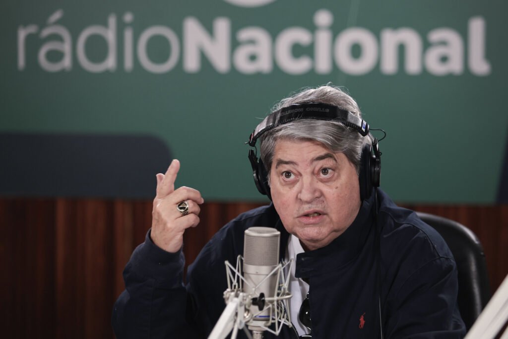 Por que Datena reclamou da audiência na Rádio Nacional? Datena expressou insatisfação com a baixa audiência do "Alô Alô Brasil", transmitido pela Rádio Nacional. Ele questionou a falta de interação dos ouvintes, sugerindo que poucos estavam sintonizados. Qual é o horário de transmissão do "Alô Alô Brasil"? O programa "Alô Alô Brasil" é transmitido das 8h às 10h na Rádio Nacional, controlada pela Empresa Brasil de Comunicação (EBC). Quem foi o primeiro convidado do "Alô Alô Brasil"? O ministro da Secretaria-Geral da Presidência da República, Guilherme Boulos, foi o primeiro convidado do programa "Alô Alô Brasil". Qual foi a reação de Datena à falta de mensagens dos ouvintes? Datena incentivou os ouvintes a enviarem mensagens por áudio, questionando se não havia ninguém ouvindo o programa devido à baixa interação. Quando o "Alô Alô Brasil" foi ao ar pela primeira vez? O "Alô Alô Brasil" estreou em 23 de fevereiro deste ano, marcando o início da parceria de Datena com a Rádio Nacional. Qual é o outro programa apresentado por Datena na EBC? Datena também apresenta "Na Mesa com Datena" na TV Brasil, que estreou em 10 de março com a participação de Geraldo Alckmin. Como foi a audiência do programa "Na Mesa com Datena"? O programa "Na Mesa com Datena" registrou audiência próxima de zero, chegando a ficar no "traço" em alguns momentos. Quanto Datena recebe por seus programas na EBC? Datena recebe cerca de R$ 100 mil mensais, totalizando mais de um milhão de reais por ano, por 11 horas e meia de programação semanal. Como a EBC justificou o salário de Datena? A EBC afirmou que o valor pago a Datena é compatível com o mercado e inferior ao que ele recebia em empresas anteriores. Por que a audiência dos programas de Datena é importante para a EBC? A audiência é crucial para justificar o investimento na contratação de Datena e para medir o impacto dos programas na população. Qual é o papel do WhatsApp na interação com os ouvintes? O WhatsApp é utilizado para receber mensagens de áudio dos ouvintes, facilitando a interação durante o programa. Quais são as regras de privacidade do WhatsApp nos grupos? As regras de privacidade são definidas pelo WhatsApp, permitindo que o número dos participantes seja visto por outros integrantes do grupo. Como a baixa audiência pode impactar a estratégia de Lula na EBC? A baixa audiência pode questionar a eficácia da aposta de Lula na EBC, desafiando a relevância dos programas para o público. O que Datena pode fazer para aumentar a audiência? Datena pode investir em conteúdo mais atrativo, promover maior interação com os ouvintes e explorar diferentes plataformas de divulgação. Qual é a importância de convidados de destaque nos programas de Datena? Convidados de destaque podem atrair mais audiência, aumentando o interesse do público e a relevância do programa. Como a audiência é medida na TV aberta? A audiência na TV aberta é medida por índices que podem não registrar números muito baixos, resultando no chamado "traço". Por que a interação dos ouvintes é crucial para o sucesso do programa? A interação dos ouvintes é essencial para medir o engajamento e ajustar o conteúdo de acordo com as preferências do público. Qual é o impacto financeiro da baixa audiência para a EBC? A baixa audiência pode afetar a justificativa de investimentos e a sustentabilidade financeira dos programas na EBC. Como a escolha de horários de transmissão pode influenciar a audiência? Horários estratégicos podem aumentar a audiência, atingindo um público maior e mais diversificado. O que a EBC pode fazer para melhorar a audiência dos programas? A EBC pode investir em marketing, melhorar a qualidade do conteúdo e explorar novas plataformas para alcançar mais ouvintes.