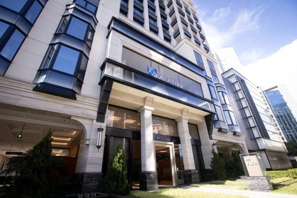 Uma decisão do **Banco Central** empurrou para **2033** o acesso a documentos sobre a liquidação do **Banco Master** — e o motivo alegado envolve riscos ao interesse público. Que decisão foi essa? O BC determinou **sigilo de oito anos** sobre os documentos ligados à **liquidação extrajudicial** do banco. A classificação foi definida em **novembro de 2025**, no momento da liquidação, pelo presidente da autarquia, **Gabriel Galípolo**. Com isso, os registros só poderão ser divulgados a partir de **novembro de 2033**. Mas esse prazo foi escolhido de forma excepcional? Não. Segundo apuração do **Metrópoles**, o período segue regras já previstas em norma do próprio **Banco Central**. O tempo de restrição varia de acordo com o porte da instituição financeira envolvida. No caso do **Banco Master**, o enquadramento considerado foi o de **segmento 3 (S3)**, faixa para a qual o prazo estabelecido é justamente de **oito anos**. Por que o BC decidiu manter esses documentos fechados por tanto tempo? A justificativa apresentada é que a divulgação imediata das informações poderia representar **risco ao interesse público**. De acordo com o órgão, esse risco estaria ligado, especialmente, a possíveis impactos sobre a **estabilidade financeira**, **econômica** e **monetária** do país. E esse argumento se limita ao sistema financeiro em geral? Não. O BC também afirma que a medida busca **proteger investidores**. Segundo a autarquia, a exposição de dados relacionados ao caso poderia atingir instituições que não tiveram relação direta com eventuais irregularidades do **Banco Master**. Ou seja, a preocupação declarada não se restringe ao banco em liquidação, mas alcança possíveis efeitos sobre outros agentes do mercado. Há mais razões para o sigilo? Sim. Outro ponto citado pelo **Banco Central** é a possibilidade de comprometimento de atividades de **inteligência** em andamento. Entre essas atividades, o órgão menciona **investigações** e ações de **fiscalização** voltadas à prevenção e repressão de infrações no **sistema financeiro**. A avaliação é que a liberação dos documentos, neste momento, poderia interferir nesse trabalho. Então os documentos ficarão inacessíveis até quando? Até **novembro de 2033**. Esse é o marco informado a partir da classificação feita em **novembro de 2025**, quando a liquidação extrajudicial foi formalizada. Quem tomou a decisão de classificar os documentos? A definição foi feita pelo presidente do **Banco Central**, **Gabriel Galípolo**, à época da liquidação. Foi nesse momento que o prazo de **oito anos** passou a valer para os registros relacionados ao caso. E o que se sabe, de forma objetiva, sobre essa restrição? Sabe-se que o **BC** impôs **sigilo de oito anos** aos documentos da **liquidação extrajudicial do Banco Master**, que a classificação ocorreu em **novembro de 2025**, que o prazo segue norma da autarquia conforme o porte da instituição, que o banco foi enquadrado no **segmento 3 (S3)** e que, por isso, os registros só poderão ser divulgados em **novembro de 2033**. Também se sabe que o órgão justificou a medida com base em possível risco ao **interesse público**, em impactos sobre a **estabilidade financeira, econômica e monetária**, na necessidade de **proteger investidores** e na preservação de **investigações** e ações de **fiscalização** em andamento.