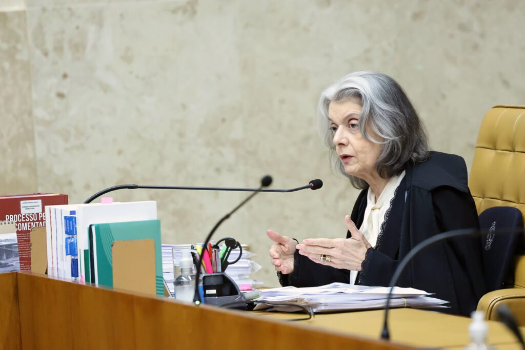 Quando uma ministra do topo do Judiciário admite que ouve dentro de casa um “chega, sai disso”, a pergunta deixa de ser apenas política e vira algo muito maior: o que está acontecendo para que até a família queira distância desse lugar? A resposta começa por um ponto desconfortável. Não se trata só de cansaço, nem apenas da rotina pesada de um tribunal. O que apareceu no relato foi uma pressão que ela mesma classificou de forma dura: “sexista, machista” e “desmoralizante”. Mas por que essa escolha de palavras pesa tanto? Porque ela sugere que o problema não está apenas no cargo, e sim no ambiente que cerca quem ocupa esse espaço. Se a pressão chega a esse nível, o efeito não recai só sobre quem já está lá. E então surge outra dúvida: isso pode afastar futuros nomes da Corte? Segundo a própria ministra, sim. Ela afirmou que algumas pessoas podem não querer ir, justamente porque a família não quer que elas fiquem. E é aqui que muita gente se surpreende: a resistência não viria apenas do debate público, da exposição ou das críticas externas, mas também do impacto íntimo, doméstico, silencioso. Só que o que, exatamente, levou essa fala a ganhar tanta atenção agora? Porque ela não surgiu isolada. A declaração foi feita durante um evento da Fundação FHC, quando a ministra revelou o que escuta dos familiares: “Cármen, sai disso. Chega. Já fez o que tinha que fazer”. Mas há um detalhe que quase ninguém percebe de imediato: essa fala aparece num momento em que sua permanência no centro das decisões ainda tem prazo longo pela frente. Então por que o tema da saída voltou com tanta força? A resposta passa pelo peso acumulado da função. Ela mencionou a quantidade de processos em tramitação no Supremo como uma “avalanche”, algo capaz de provocar até “adoecimento físico”. O que acontece depois muda tudo, porque a discussão deixa de ser apenas institucional e passa a tocar o limite humano de quem julga. Se a carga é tão intensa, haveria espaço para uma aposentadoria antecipada? Há essa possibilidade. Embora precise se aposentar compulsoriamente apenas em abril de 2029, existe a chance de saída antes desse prazo, como ocorreu com Luís Roberto Barroso. E essa hipótese abre outra camada da história: uma eventual vaga significaria nova indicação para a cúpula do Judiciário. Mas será que esse é o centro da questão? Ainda não. O ponto mais sensível talvez esteja em outro lugar. Hoje, Cármen Lúcia é a única ministra em atuação no STF. Isso torna sua fala ainda mais simbólica, especialmente depois de pressões por maior presença feminina na Corte não terem se convertido em novas nomeações. Então a pergunta inevitável aparece: quando ela fala em discurso “sexista, machista, desmoralizante”, está falando apenas de si? Tudo indica que não. O alcance da declaração é maior porque toca na imagem do próprio tribunal e no tipo de ambiente que ele projeta para quem poderia chegar até lá. E tem mais um elemento que reacende a curiosidade no meio dessa história: ao mesmo tempo em que relata esse desgaste, a ministra também aponta um caminho para enfrentar a crise de credibilidade da Corte. Qual seria? Para ela, a resposta envolve mais transparência. Cármen citou a publicidade da própria agenda como exemplo e defendeu mais explicação e abertura dentro do Judiciário. Isso ganha peso porque, em março, apenas Cristiano Zanin, Luiz Fux e ela registraram compromissos públicos no sistema. E é aqui que a maioria para e pensa: se a transparência é vista como parte da solução, o problema de confiança pode ser ainda mais profundo do que parece. Além disso, ela foi escolhida relatora do código de ética que o presidente do STF, Edson Fachin, pretende implementar. Isso muda a leitura de tudo, porque mostra que, mesmo sob pressão, ela continua no centro de discussões decisivas sobre o futuro da Corte. Então a pergunta final fica inevitável: ela quer sair? O que ela revelou, até aqui, não foi um anúncio de saída, mas a exposição de um desgaste real, familiar e institucional, que ajuda a explicar por que permanecer no STF pode custar mais do que o público imagina. E talvez o ponto principal esteja justamente aí: quando uma ministra diz que a própria família pede que ela deixe o cargo, o recado não fala apenas sobre uma decisão pessoal. Ele lança uma dúvida incômoda sobre o preço de ocupar um dos postos mais altos do país — e sobre quantos ainda estarão dispostos a pagar esse preço.