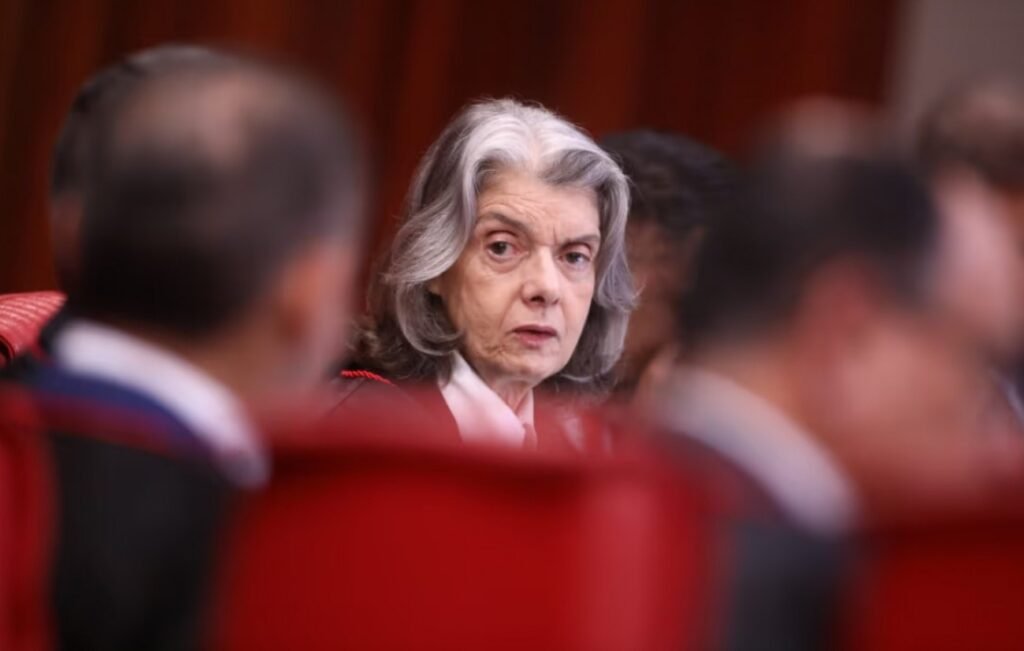 Ela decidiu sair antes da hora, e o momento dessa escolha diz mais do que o anúncio em si. Mas por que uma mudança de calendário, em uma corte tão sensível, chama tanta atenção? Porque não se trata apenas de uma troca de cadeira. Quando a presidência de um tribunal eleitoral é antecipada em um ano decisivo, o gesto inevitavelmente levanta uma pergunta: o que tornou impossível esperar mais alguns dias? A resposta começou a aparecer no fim de uma sessão de julgamentos, quando foi comunicado que a saída do comando aconteceria antes do previsto. A eleição para a nova presidência, que só deveria ocorrer no fim do mês, foi puxada para 14 de abril. E isso imediatamente acendeu outra dúvida: o que justificaria acelerar uma transição que, até então, seguia outro cronograma? Segundo a própria ministra, a razão está no acúmulo de funções. Ela afirmou que não se apega a cargos e destacou a necessidade de equilibrar suas responsabilidades entre o Tribunal Superior Eleitoral e o Supremo Tribunal Federal. Em outras palavras, permanecer nas duas frentes comprometeria o desempenho pleno. Só que há um ponto que quase ninguém ignora quando olha para a sequência dos fatos: o anúncio veio um dia depois de críticas públicas sobre a condução de processos ligados às eleições no Rio de Janeiro. E por que esse detalhe pesa tanto? Porque, em ambientes de poder, o tempo de uma decisão costuma ser tão importante quanto a decisão em si. Quando uma saída é anunciada logo após um embate, a leitura política se impõe, mesmo que a justificativa formal seja administrativa. E é justamente aí que a maioria se surpreende: não foi apenas uma despedida, mas uma mudança com efeito direto sobre a organização interna da Justiça Eleitoral às vésperas do pleito de 2026. Quem assume, então, e por que isso muda o jogo? A nova composição já foi definida: Nunes Marques ficará na presidência, com André Mendonça na vice. São eles que terão a responsabilidade de conduzir as eleições gerais de outubro de 2026, quando os brasileiros escolherão presidente da República, governadores, senadores e deputados. E essa informação, por si só, abre uma nova camada de interesse: por que esses nomes despertam tanta expectativa? Porque o histórico recente do tribunal tornou cada mudança de comando altamente observada. Nos últimos anos, decisões da Corte tiveram impacto profundo no cenário político nacional. Entre elas, o julgamento que tornou Jair Bolsonaro inelegível em 2023. Naquela ocasião, apenas dois ministros votaram a favor do ex-presidente: Raul Araújo e o próprio Nunes Marques. O que acontece depois disso muda toda a percepção sobre a sucessão no tribunal. Mas isso significa uma reviravolta automática? Não. E esse é o detalhe que mais prende atenção. A troca no comando não apaga decisões passadas, nem redefine sozinha o rumo do país. Ainda assim, altera o centro de gravidade de uma instituição que terá papel decisivo em 2026. E quando o tribunal responsável por organizar e conduzir a eleição muda de mãos antes do previsto, a pergunta deixa de ser apenas jurídica e passa a ser também política. Então por que tanta gente vê nessa antecipação algo maior do que uma simples saída? Porque ela acontece em um ambiente já marcado por tensão, memória recente de julgamentos controversos e expectativa sobre os próximos passos da Justiça Eleitoral. A presidência que se encerra antes do prazo abre espaço para outra, com nomes que já carregam significado próprio dentro desse debate. No fim, o ponto principal não está apenas no adeus de Cármen Lúcia, mas no que esse adeus antecipa. A saída acelerada, após o embate com Gilmar Mendes e às portas da definição do comando que conduzirá as eleições de 2026, transforma um gesto administrativo em sinal político. E talvez a pergunta mais importante nem seja por que ela saiu agora, mas o que essa pressa revela sobre o que já começou a se mover nos bastidores.