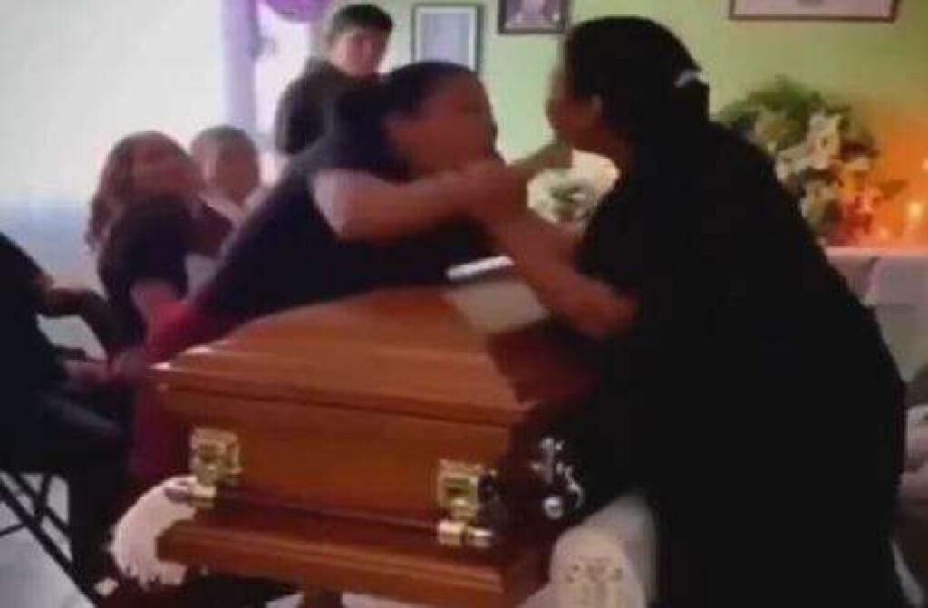 Tudo parecia seguir o silêncio esperado de uma despedida, até que um gesto diante do **caixão** transformou o luto em choque. Como uma cerimônia fúnebre pode sair do recolhimento para uma cena de confronto físico? A resposta começa com algo aparentemente simples: uma aproximação para o último adeus. Uma das mulheres presentes se dirigiu ao caixão para se despedir, mas a forma como fez isso chamou atenção imediata. Não foi apenas um gesto qualquer. Havia ali uma demonstração de afeto que ultrapassava o que muitos esperariam naquele momento. E por que isso causou tanta reação? Porque outra mulher, que também participava da cerimônia, percebeu esse comportamento e passou a questionar o tipo de vínculo que existia entre ela e o falecido. O que parecia ser apenas um instante íntimo de despedida rapidamente se transformou em uma dúvida incômoda. Afinal, quem era aquela mulher para agir daquela maneira? A resposta veio de forma direta e incendiária: ela confirmou que mantinha uma **relação amorosa** com o homem que estava sendo velado. E é justamente nesse ponto que tudo muda. Porque a outra mulher não era apenas uma conhecida surpresa com a cena. Ela também tinha um envolvimento amoroso com o falecido. O que até então era uma cerimônia de despedida passou a revelar, no pior momento possível, uma verdade escondida. Mas como essa descoberta evoluiu tão rápido para uma confusão? Porque a revelação não ficou no campo das palavras. O que começou como uma **discussão acalorada** avançou em segundos para agressões físicas diante de familiares e amigos. O ambiente, que já estava emocionalmente carregado, se rompeu de vez. Empurrões, gritos e tensão tomaram conta do velório. Há, porém, um detalhe que quase ninguém ignora quando vê as imagens: a briga não aconteceu em um canto afastado, longe dos olhares. Ela ocorreu diretamente sobre o **caixão**. As duas mulheres se agarraram em cima dele, em uma cena que deixou os presentes em estado de surpresa. A intensidade do confronto foi tanta que a tampa chegou a ser parcialmente deslocada. E o que fizeram as pessoas que estavam ali? Intervieram para separar as duas e tentar conter a situação. Só que o impacto já estava criado. A cerimônia foi temporariamente interrompida, e o que deveria ser um momento de despedida passou a ser lembrado pela confusão. O que acontece depois amplia ainda mais a repercussão: tudo foi **registrado em vídeo**. É aqui que muita gente se surpreende ainda mais. O episódio não ficou restrito aos presentes no velório. As imagens circularam nas **redes sociais**, onde acumularam milhares de visualizações e comentários. A reação do público misturou humor, espanto e críticas. Para muitos usuários, a situação pareceu tão absurda quanto constrangedora, especialmente por ter acontecido em um contexto de luto. Mas onde exatamente isso aconteceu? Só na metade dessa história o cenário se revela por completo: o confronto ocorreu durante uma cerimônia fúnebre em **Veracruz, no México**. E esse detalhe ajuda a localizar o episódio, mas não reduz o que mais chama atenção nele: a forma como uma verdade escondida veio à tona no instante mais improvável. Então qual é o ponto central de tudo isso? Duas mulheres descobriram, no velório, que ambas mantinham um relacionamento amoroso com o falecido, e essa revelação desencadeou uma briga física diante de todos. O vídeo viralizou, a cerimônia foi interrompida e a cena passou a circular muito além daquele espaço. Só que há algo que continua prendendo a atenção de quem se depara com esse caso: não foi apenas uma briga em um velório. Foi a exposição repentina de uma vida afetiva que, até aquele momento, parecia separada em versões diferentes. E quando essas versões se encontraram, o luto deixou de ser silencioso — e virou confronto público.