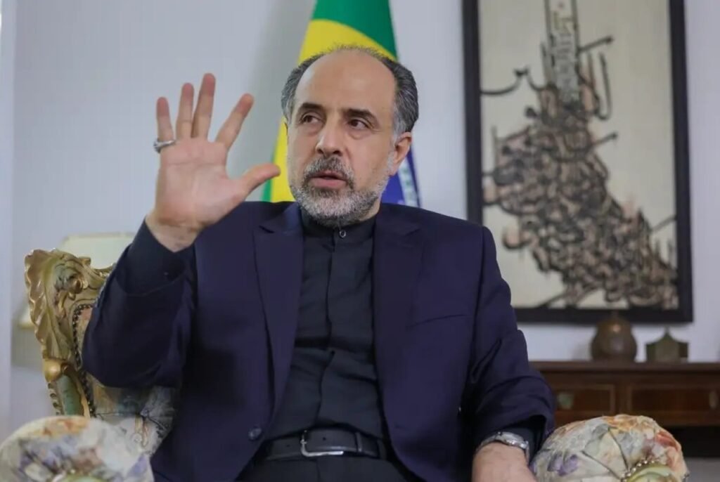 Ele entrou no **Congresso Nacional** cercado por forte segurança, e a cena por si só já levantou a pergunta mais importante: o que o **embaixador do Irã no Brasil**, **Abdollah Nekounam Ghadiri**, foi buscar entre gabinetes e comissões da Câmara? A resposta começou a aparecer ao longo da manhã de terça-feira, dia 7. Ghadiri circulou por espaços ligados a parlamentares da **esquerda**, tentando obter algum tipo de apoio político. Apoio para quê? Para reagir, em discursos nos plenários e também na mídia, às ameaças feitas por **Donald Trump**, que falou em dizimar “uma civilização inteira”. Mas essa movimentação se limitava a uma defesa diplomática diante da crise internacional? Não. Havia também uma preocupação prática e antiga por trás da agenda do representante iraniano. Uma de suas principais buscas envolve uma parceria que o **Irã** tenta há anos com o **Banco do Brasil**, numa tentativa de driblar as **sanções econômicas** impostas ao país. Onde essa articulação apareceu de forma mais visível? Uma das agendas de Ghadiri ocorreu na **Comissão de Direitos Humanos da Câmara**, presidida por **Alice Portugal**, do **PCdoB da Bahia**. A presença do diplomata nesse espaço chama atenção justamente porque o tema dos direitos humanos carrega um peso inevitável quando se fala do regime iraniano. E o que foi tratado ali? Segundo as informações disponíveis, não consta que o embaixador tenha abordado a morte de mais de **60 mil iranianos** pelo regime. Também não consta que tenha defendido o uso de **crianças e adolescentes como escudo humano** contra ataques dos **Estados Unidos**. O foco conhecido da visita estava em outra frente: construir ambiente político para o Irã em Brasília e reforçar interesses ligados à sua situação econômica e diplomática. Por que isso importa no contexto brasileiro? Porque a busca por apoio dentro do Congresso não se resume a gestos protocolares. Quando um embaixador procura parlamentares, comissões e espaços de fala pública, ele tenta abrir canais de influência, moldar narrativas e encontrar vozes dispostas a ecoar sua posição. Nesse caso, a tentativa se conecta diretamente à pressão internacional sofrida pelo Irã e à necessidade de aliviar os efeitos das sanções. E qual é, afinal, o ponto mais sensível dessa movimentação? Justamente a tentativa de avançar numa parceria com o **Banco do Brasil**. Esse interesse não surgiu agora. Trata-se de uma iniciativa buscada há anos pelo Irã, com o objetivo de criar uma via que ajude o país a contornar restrições econômicas externas. É esse aspecto que dá à visita um peso maior do que o de uma simples rodada de conversas políticas. A presença de um forte aparato de segurança também ajuda a entender a dimensão da visita? Sim. O embaixador circulou com proteção pessoal reforçada e apoio da **Polícia Legislativa**, o que transformou sua passagem pelo Congresso em um movimento de alta visibilidade. Não foi uma agenda discreta, nem uma visita sem repercussão potencial. Então o que se sabe, de forma objetiva, sobre essa passagem por Brasília? Sabe-se que **Abdollah Nekounam Ghadiri** esteve no **Congresso Nacional** na manhã de terça-feira, dia 7, com forte esquema de segurança. Sabe-se que visitou gabinetes de parlamentares da **esquerda** e teve agenda na **Comissão de Direitos Humanos da Câmara**, presidida por **Alice Portugal**. Sabe-se que buscava apoio político e espaço em discursos e na mídia contra ameaças de **Donald Trump**. E sabe-se, sobretudo, que uma de suas maiores preocupações é destravar uma parceria que o **Irã** tenta há anos com o **Banco do Brasil**, para driblar as **sanções econômicas**.