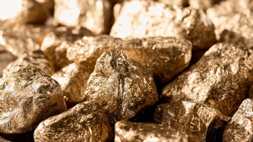 Uma descoberta de quase **R$ 900 bilhões** começou a redesenhar o mapa mineral da América do Sul. Mas onde está essa reserva que passou a atrair tanta atenção tão perto do Brasil? Ela fica na **Cordilheira dos Andes**, na divisa entre **Argentina e Chile**, em uma região de **altitude extrema** e **clima rigoroso**, onde uma nova jazida desponta como um dos projetos minerais mais relevantes em desenvolvimento no continente. E por que ela chama tanto interesse? Porque não se trata apenas de uma área com **ouro**. As estimativas preliminares, calculadas com base nos preços atuais dos metais no mercado internacional, apontam um valor próximo de **R$ 900 bilhões**. Isso coloca a reserva entre as maiores descobertas recentes do setor mineral e amplia o peso estratégico da região nas cadeias globais de fornecimento. Mas o que existe ali além do ouro? As análises iniciais indicam também presença significativa de **cobre** e de outros minerais associados. E por que isso importa tanto agora? Porque o **cobre** é considerado essencial em um cenário de **transição energética**. Ele é usado em **redes elétricas**, **veículos elétricos**, **telecomunicações** e **centros de dados**, o que transforma a jazida em um ativo de interesse não só para a mineração tradicional, mas também para setores ligados à **tecnologia**, **infraestrutura** e **energia limpa**. Essa descoberta afeta apenas Argentina e Chile? Não. Embora esteja fora do território brasileiro, o projeto tende a intensificar os **fluxos comerciais regionais**. Como isso pode acontecer? Com a necessidade de escoar produção e garantir suprimentos, **portos**, **ferrovias** e empresas de **logística** de países vizinhos podem ser acionados. Além disso, fornecedores de **equipamentos**, **químicos industriais**, **engenharia** e **serviços ambientais** de diferentes países sul-americanos podem entrar na cadeia de suprimentos. E qual pode ser o espaço do Brasil nesse movimento? O avanço do projeto abre oportunidades para empresas brasileiras de **bens de capital**, **transporte pesado**, **sondagem** e **tecnologia ambiental**. Isso significa que, mesmo sem estar dentro do território nacional, a nova reserva pode gerar efeitos econômicos indiretos para o país por meio da integração produtiva e logística da região. Se o potencial é tão grande, o que já começou a mudar? Com a divulgação das primeiras estimativas, **multinacionais de mineração** passaram a disputar espaço no projeto. De que forma? Por meio de **parcerias**, **aquisições** e **acordos de desenvolvimento conjunto**. A localização na fronteira também favorece **rotas binacionais** e integração com outros complexos minerais, como **Filo del Sol** e **Josemaría**, o que amplia a viabilidade logística e operacional. Mas explorar uma reserva desse porte em plena montanha é simples? Não. Para viabilizar a extração em larga escala, estão previstos investimentos coordenados em várias frentes. Isso inclui **obras complexas em altitude**, além do uso de **tecnologias avançadas de segurança e monitoramento**. O ambiente impõe dificuldades naturais e exige planejamento técnico detalhado. Quais são os principais obstáculos? O projeto enfrenta desafios **técnicos**, **ambientais** e **regulatórios**, comuns em áreas de montanha com **geleiras** e **ecossistemas frágeis**. Além disso, a coordenação entre **Argentina e Chile** exige acordos sobre **licenciamento**, **tributação**, **infraestrutura compartilhada** e **padrões de segurança**. Sem esse alinhamento, o avanço da operação pode se tornar mais lento e mais complexo. E o que deve acontecer agora? Os próximos anos devem ser marcados por **sondagens detalhadas**, **estudos de viabilidade econômica e ambiental**, definição de modelos de parceria com **comunidades** e **governos**, além da implementação gradual de infraestrutura e de **testes em escala piloto**. A intenção é buscar equilíbrio entre **retorno econômico** e **responsabilidade socioambiental**. Então, afinal, o que torna essa descoberta tão relevante? A combinação de **ouro**, **cobre** e outros minerais estratégicos, em uma reserva avaliada preliminarmente em cerca de **R$ 900 bilhões**, localizada na divisa entre **Argentina e Chile**, em plena **Cordilheira dos Andes**, com potencial para impactar a **balança comercial** dos dois países, reforçar o papel da **América do Sul** como fornecedora de insumos essenciais e abrir espaço para empresas brasileiras em áreas como **logística**, **equipamentos**, **sondagem** e **tecnologia ambiental**.