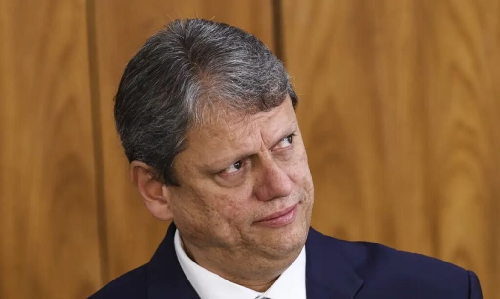 O que é a escala 6x1 e por que está em debate? A escala 6x1 é um modelo de trabalho onde o funcionário trabalha seis dias e descansa um. O debate surge por preocupações de que o tema esteja sendo tratado de forma populista, segundo Tarcísio de Freitas. Por que Tarcísio de Freitas critica o populismo na escala 6x1? Tarcísio acredita que o debate está sendo conduzido de forma inadequada, com um viés populista que pode desviar o foco das reais necessidades do mercado e dos trabalhadores. Qual é a posição de Tarcísio sobre a escala 6x1? Ele defende a manutenção do modelo, mas ressalta que o tema deve ser tratado com cautela, evitando decisões precipitadas que não considerem o contexto econômico atual. Como o empresariado reage à posição de Tarcísio? O empresariado vê com bons olhos a cautela de Tarcísio, pois ele acena positivamente ao setor, indicando que mudanças abruptas não são ideais no momento. Qual o contexto do "Jantar com Empresários"? O evento, promovido pelo grupo Mercado e Opinião, reúne autoridades e representantes do setor produtivo para discutir temas econômicos e políticos relevantes para o país. Quais críticas Tarcísio fez ao cenário político e econômico? Ele criticou a ausência de reformas estruturais recentes e destacou que a última grande mudança econômica foi o Plano Real, questionando a falta de novidades do atual governo. Como Tarcísio vê a liderança atual do Brasil? Tarcísio considera a liderança atual envelhecida, com processos lentos e pouca capacidade de inovação, defendendo a necessidade de renovação política. Por que Tarcísio questiona a atuação do Judiciário? Ele sugere que a interferência de outros Poderes ocorre por falta de decisões claras do Executivo, levantando preocupações sobre a desorganização no sistema político. Qual a visão de Tarcísio sobre a reeleição do atual governo? Ele provoca a plateia questionando qual seria o projeto de Brasil do PT e o que há de novo, sugerindo que a atual gestão se beneficia de avanços do passado. Como Tarcísio propõe fazer a diferença na política? Ele defende que é hora de uma nova geração assumir as rédeas do país, trazendo inovação e dinamismo para evitar que o Brasil fique à deriva. Quais são as consequências de um debate populista sobre a escala 6x1? Um debate populista pode levar a decisões que não consideram as necessidades reais do mercado e dos trabalhadores, resultando em impactos negativos na economia. Como a ausência de reformas estruturais afeta o Brasil? A falta de reformas impede o avanço econômico e a modernização do país, mantendo processos lentos e uma liderança sem capacidade de inovação. Por que a renovação política é importante para o Brasil? A renovação política pode trazer novas ideias, dinamismo e inovação, essenciais para enfrentar os desafios atuais e futuros do país. Como a interferência de Poderes afeta a governabilidade? A interferência pode gerar instabilidade e desorganização, dificultando a implementação de políticas eficazes e claras pelo Executivo. Qual é o papel do empresariado no debate sobre a escala 6x1? O empresariado busca um equilíbrio que considere as necessidades do mercado e dos trabalhadores, evitando mudanças abruptas que possam prejudicar a economia.