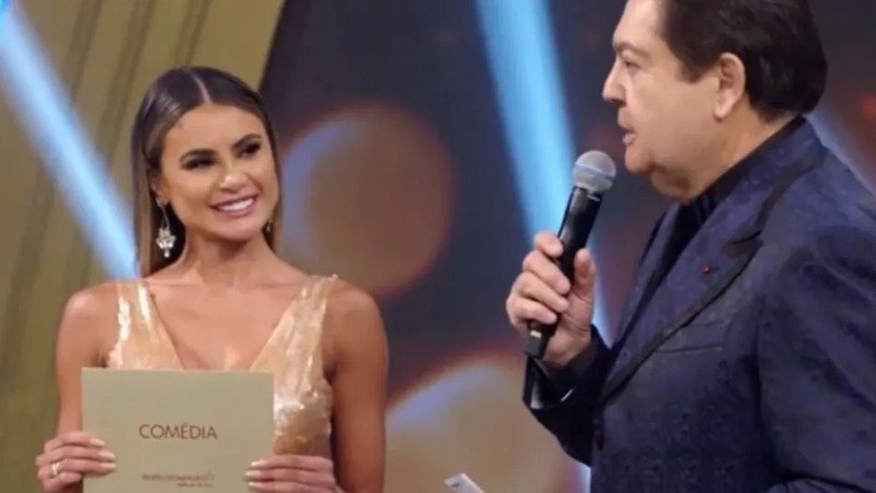 Ela saiu da prisão, mas diz que uma parte de si ainda ficou presa no que viveu. Quem é a mulher por trás desse relato que voltou a chamar atenção? Trata-se de **Natacha Horana**, de **34 anos**, conhecida nacionalmente por ter integrado o balé do **Faustão** na época em que o apresentador ainda comandava a programação dominical da **TV Globo**. Agora, passado um ano desde que recuperou a liberdade, ela fala publicamente sobre o que enfrentou e sobre as marcas que diz carregar até hoje. Mas por que esse período se tornou tão decisivo em sua vida? Porque Natacha foi presa em **novembro de 2024** e permaneceu cerca de **quatro meses** encarcerada. Na ocasião, ela foi investigada por **suposto envolvimento com organizações criminosas** e **lavagem de dinheiro**. Foi depois dessa experiência que, segundo seu próprio relato, começou um processo profundo de transformação pessoal. O que mudou desde então? Segundo Natacha, praticamente tudo. Ao falar sobre esse recomeço, ela afirma que precisou rever a própria relação consigo mesma, com os outros e com o mundo ao redor. “**Existe um processo interno muito profundo. Eu precisei reaprender muita coisa sobre mim, sobre as pessoas e sobre o mundo. Também precisei aceitar que eu não era mais a mesma pessoa de antes**”, disse. E essa mudança aconteceu de forma simples? Não. O que ela descreve é um caminho de reconstrução lento e marcado por sofrimento. Natacha afirma que ainda acredita carregar **traumas** do período em que esteve presa. Para ela, a experiência deixou marcas que não desapareceram com o fim do encarceramento. Que marcas foram essas? Em seu desabafo, ela relata ter vivido momentos de **medo**, **tristeza** e **isolamento**. Não fala de uma superação instantânea, mas de um processo gradual, feito aos poucos. “**Eu passei por momentos muito difíceis, de medo, de tristeza, de isolamento, e precisei me reconstruir aos poucos**”, refletiu. Como ela tem lidado com essas consequências? Natacha conta que faz **acompanhamento psicológico**. Segundo a bailarina, o cuidado com a **saúde mental** se tornou parte essencial da tentativa de reorganizar a própria vida depois do que aconteceu. Esse suporte, de acordo com ela, tem sido importante para enfrentar os efeitos emocionais deixados pela prisão. Quais efeitos ela relata com mais clareza? Entre os impactos mencionados, estão **crises de ansiedade** e **síndrome do pânico**. Ao falar sobre o tratamento, ela reconhece a importância desse processo para seguir em frente. “**O tratamento me ajudou muito nesse processo de reconstrução. Eu acho que cuidar da saúde mental é algo essencial, principalmente depois de experiências tão intensas**”, afirmou. Então o que esse um ano de liberdade representa para ela? Mais do que uma data, representa um marco de recomeço. Não como apagamento do passado, mas como tentativa de reconstrução depois de um período que, segundo suas próprias palavras, deixou feridas profundas. A liberdade, nesse caso, aparece acompanhada de um esforço interno contínuo para lidar com o que permaneceu. E o que fica mais evidente em sua fala? Que o fim da prisão não significou o fim das consequências. Um ano depois de deixar a cadeia, **Natacha Horana** diz que ainda convive com os reflexos emocionais do que viveu, após ter sido presa em **novembro de 2024**, investigada por **suposto envolvimento com organizações criminosas** e **lavagem de dinheiro**, ter passado cerca de **quatro meses** encarcerada e, desde então, buscar reconstrução com **tratamento psicológico**, após relatar **traumas**, **ansiedade**, **síndrome do pânico**, além de momentos de **medo**, **tristeza** e **isolamento**.