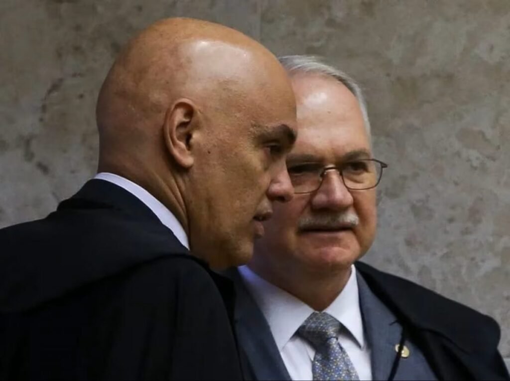 Uma tentativa de mudar o rumo de um dos processos mais sensíveis ligados ao 8 de Janeiro acabou travada antes mesmo de avançar. Mas o que exatamente estava em jogo? Não se tratava ainda do julgamento final dos fatos, nem de uma nova denúncia, e sim de uma investida para afastar um dos nomes centrais do caso. A pergunta que surgiu foi direta: seria possível declarar Alexandre de Moraes suspeito para atuar nesse processo? O pedido apareceu a partir da defesa de um réu já envolvido na apuração dos ataques às sedes dos Três Poderes. E por que isso importa tanto? Porque, quando se tenta afastar um ministro sob alegação de falta de isenção, o impacto pode ir muito além de um simples movimento processual. Dependendo da decisão, toda a condução do caso poderia ganhar outro rumo. Só que há um ponto que quase passa despercebido: não basta levantar uma acusação de parcialidade para que ela seja aceita. Era preciso mostrar, de forma concreta, que existiria base legal para sustentar a suspeição. E foi justamente aí que a tentativa encontrou sua principal barreira. Quem decidiu sobre isso foi Edson Fachin, presidente do Supremo Tribunal Federal. E o que ele fez? Rejeitou o pedido. A decisão foi tomada na última terça-feira, dia 7, e fechou a porta para a tese apresentada pela defesa. Mas por que Fachin negou a solicitação? Segundo a decisão, a mera indicação de publicações em redes sociais e matérias jornalísticas não é suficiente para afirmar que um juiz seja suspeito. Em outras palavras, citar conteúdos públicos ou reportagens, por si só, não comprova inimizade nem aconselhamento a uma das partes do processo, hipóteses que poderiam sustentar esse tipo de afastamento. E é aqui que muita gente se surpreende: o argumento apresentado falava em suposto “antagonismo de cunho político”. Mas a resposta do Supremo foi no sentido de que essa alegação, sem elementos capazes de se encaixar nas hipóteses normativas previstas, não bastava para retirar Moraes do caso. A discussão, portanto, não ficou no campo político, e sim no terreno estritamente jurídico. Mas quem fez esse pedido? A solicitação partiu de José Celso Cornolo Junior, réu no Supremo por envolvimento nos atos golpistas de 8 de Janeiro de 2023. E o que pesa contra ele? Essa é a parte que recoloca o caso em uma dimensão ainda maior. A Primeira Turma da Corte aceitou, em junho, a denúncia contra ele. Com isso, José Celso passou a responder por cinco crimes: associação criminosa armada, tentativa de abolição violenta do Estado Democrático de Direito, golpe de Estado, dano qualificado e deterioração de patrimônio tombado. O que acontece depois muda o foco de tudo, porque a discussão deixa de ser apenas sobre quem julga e volta ao centro da questão: o conteúdo da ação penal. Então o processo já será julgado agora? Ainda não. O julgamento da ação penal não tem data definida. E esse detalhe mantém a tensão em aberto, porque a rejeição do pedido contra Moraes não encerra o caso principal. Pelo contrário: ela apenas confirma que, neste momento, a condução segue sem a mudança pretendida pela defesa. Mas há uma camada final que torna tudo ainda mais relevante. Quando o Supremo recusa um pedido desse tipo, ele não está apenas respondendo a uma contestação individual. Também está sinalizando qual padrão de prova considera necessário para admitir a suspeição de um magistrado em um processo de enorme repercussão. No fim, o ponto central é esse: Fachin barrou a tentativa de declarar Moraes suspeito no caso do 8 de Janeiro porque entendeu que os elementos apresentados não eram suficientes para sustentar, em termos legais, a alegação de parcialidade. Só que a história não para aí. A decisão resolve uma disputa processual importante, mas deixa de pé a pergunta que continua puxando tudo para frente: quando o mérito dessa ação finalmente chegar a julgamento, o que ainda pode emergir desse processo?