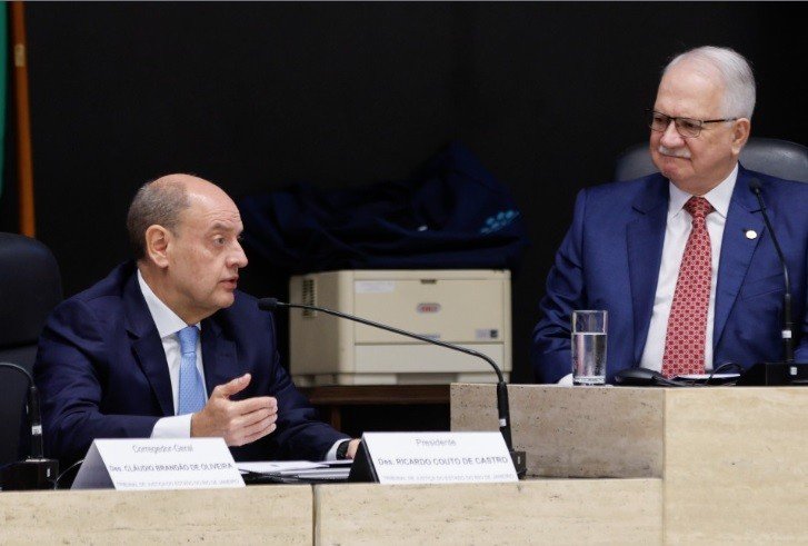 A promessa parece simples, mas esconde um impasse que mexe com dinheiro, poder e um limite que nunca deixou de ser sensível: “vamos colocar ordem com responsabilidade e respeito”. Ordem em quê, exatamente? Naquilo que há anos provoca debate dentro e fora das instituições: os chamados penduricalhos, verbas extras que podem elevar a remuneração além do teto constitucional do funcionalismo público. A fala foi feita com um cuidado que chama atenção, porque não veio acompanhada apenas de cobrança por controle, mas também de uma defesa explícita da valorização de quem atua na magistratura. Mas por que essa declaração ganhou tanto peso agora? Porque ela surge no momento em que novas regras foram aprovadas para limitar esses pagamentos adicionais nas carreiras do Judiciário e do Ministério Público. Em tese, o objetivo era organizar o sistema remuneratório, reduzir distorções e aproximar a prática do teto constitucional. Só que é justamente aí que a discussão começa a ficar mais delicada. Se a intenção era limitar, onde está o problema? O ponto que acendeu o alerta é que, ao regulamentar essas normas, os conselhos responsáveis acabaram criando, na prática, novos tipos de verbas extras. Entre elas, auxílio-moradia. E é nesse ponto que muita gente se surpreende: uma medida apresentada como freio passou a ser vista por especialistas como algo que pode manter, ou até reconfigurar, os próprios mecanismos que buscava conter. Então a fala sobre “colocar ordem” foi uma resposta a essa contradição? Em parte, sim. O discurso tenta equilibrar duas pressões que caminham juntas, mas nem sempre na mesma direção. De um lado, a necessidade de respeitar o teto constitucional e controlar gastos. De outro, o reconhecimento de que magistrados exercem funções em contextos difíceis e, segundo a própria fala, até inseguros, especialmente em casos ligados ao crime organizado e ao tráfico de drogas. Mas há um detalhe que quase ninguém percebe de imediato: o debate não gira apenas em torno de cortar ou manter benefícios. Ele envolve também quem tem o poder de definir as regras enquanto não existe uma lei nacional específica sobre o tema. E isso muda bastante o tamanho da discussão. Quem está decidindo isso agora? Nesta semana, o Conselho Nacional de Justiça e o Conselho Nacional do Ministério Público aprovaram um texto com novas regras para essas carreiras. A resolução foi editada pelos presidentes Edson Fachin, no CNJ, e Paulo Gustavo Gonet Branco, no CNMP. Só que essa regulamentação vale até que o Congresso Nacional edite uma lei nacional sobre o assunto. Ou seja: o que parece provisório pode ter efeitos muito concretos no presente. E qual é o limite que já havia sido definido? O Supremo Tribunal Federal estabeleceu, em julgamento sobre os penduricalhos, que a soma de todas as vantagens não pode exceder 70% do valor do teto constitucional. Hoje, esse teto corresponde ao salário de um ministro do STF, em R$ 46.366,19. Esse percentual de 70% foi dividido em dois blocos de 35%. Como isso funciona na prática? Um dos blocos contempla o adicional por tempo de serviço, calculado em 5% a cada cinco anos. O outro reúne verbas como diárias, ajuda de custo para remoção, gratificação de magistério, comarca de difícil provimento, férias não gozadas e acúmulo de jurisdição. A ideia era justamente estabelecer um desenho mais claro para impedir excessos. Mas o que acontece depois muda tudo: a regulamentação aprovada agora passou a ser vista por especialistas como algo que vai na contramão do que o próprio STF havia fixado. Então o centro da controvérsia está menos no discurso e mais na execução? Exatamente. A frase de Fachin aponta para racionalidade, responsabilidade fiscal e respeito à magistratura. Só que o debate real está em saber se a norma recém-aprovada organiza o sistema ou se abre novas brechas dentro dele. E essa é a parte mais sensível, porque a promessa de ordem só se sustenta se o limite for, de fato, limite. E onde essa fala foi feita? No Rio de Janeiro, durante um evento em que Fachin defendeu a necessidade de organizar o sistema remuneratório do Judiciário sem desvalorizar as carreiras. A escolha das palavras não foi casual. Ao falar em respeito à magistratura e à vida de quem se dedica ao serviço diário à comunidade, ele sinalizou que a discussão não será tratada apenas como planilha de gastos. Mas, no fim, qual é o ponto principal? Que o presidente do STF assumiu publicamente o compromisso de colocar ordem nos penduricalhos, tentando conciliar teto constitucional, responsabilidade fiscal e valorização da magistratura, justamente no momento em que a regulamentação aprovada pelos conselhos é questionada por criar novas verbas extras. A promessa foi feita. O impasse também. E o que vier a seguir pode definir não só o tamanho desses pagamentos, mas o sentido real da palavra “ordem”.