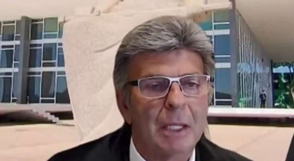 Bastou uma fala atravessada para transformar um julgamento técnico em algo muito maior: um **recado interno**, público e impossível de ignorar. Mas por que isso chamou tanta atenção? Porque não se tratou apenas de uma divergência jurídica. O que apareceu ali, diante de todos, foi um movimento com cheiro de **resposta calculada**, num ambiente já carregado por atritos recentes. E quando um ministro resolve reagir no momento exato, a pergunta deixa de ser apenas “o que foi dito?” e passa a ser: **por que foi dito agora?** A resposta começa num clima que já vinha se deteriorando. Depois de ser duramente criticado por seus próprios pares ao votar pela **absolvição de Jair Bolsonaro** no julgamento da chamada **“trama golpista”**, **Luiz Fux** passou a ser observado com ainda mais atenção. Teria ele simplesmente seguido em frente? Ou estaria esperando a hora certa para devolver o golpe? É justamente aí que a história ganha força. E onde isso aconteceu? Em meio ao julgamento que vai definir se a eleição para o **mandato-tampão de governador do Rio de Janeiro** será **direta ou indireta**. À primeira vista, o foco parecia ser apenas esse. Só que, no decorrer da sessão, surgiram comentários de **Gilmar Mendes**, **Alexandre de Moraes** e **Flávio Dino** sobre a situação da política fluminense. E foi nesse ponto que o ambiente mudou de temperatura. O que foi dito para provocar tanto? As falas giraram em torno da degradação política do estado, com menções ao histórico recente de governadores presos ou afastados. O momento mais sensível veio quando o decano afirmou que teria sido informado pelo diretor da **Polícia Federal** de que **“32 ou 34 parlamentares”** da Assembleia Legislativa do Rio receberiam **mesada do jogo do bicho**. Em seguida, resumiu o cenário com uma frase pesada: **“Deus tenha piedade do Rio de Janeiro”**. Mas por que isso atingiu Fux de forma tão direta? Porque ele é **carioca**, ligado à sua cidade natal e ao estado, e entendeu aquelas declarações como uma generalização ofensiva contra o Rio de Janeiro. Foi então que decidiu reagir. E é aqui que muita gente se surpreende: a resposta não soou como simples defesa regional. Soou como algo mais fundo, mais pessoal, mais conectado ao que vinha se acumulando nos bastidores. O que Fux disse? Segundo o relato, ele classificou aquelas falas como uma **“manifestação de profundo descrédito em relação ao Rio de Janeiro de forma generalizada”**. A frase, por si só, já marcava posição. Mas há um detalhe que quase ninguém percebe de imediato: ao defender os políticos fluminenses naquele contexto, Fux não apenas contestava o conteúdo das críticas. Ele também expunha o desconforto com a postura de colegas que, na visão do articulista, se colocam em posição moral elevada para condenar os outros. E por que isso foi lido como **troco**? Porque o gesto veio logo após o episódio em que Fux foi **esculachado por seus pares** por causa de Bolsonaro. A sequência dos fatos dá peso à interpretação de que ele aproveitou a ocasião para devolver, em público, parte da pressão que havia recebido. Não com um ataque frontal, mas com uma intervenção que jogou **areia no ventilador** num tribunal já tensionado. Só que o ponto mais importante talvez não esteja no que aconteceu ontem, e sim no que isso pode indicar daqui para frente. O que muda depois dessa reação? Segundo a leitura apresentada no artigo de **Mario Sabino**, esse movimento de Fux sugere que ele poderá ser **favorável à abertura de investigações contra Alexandre de Moraes e Dias Toffoli**, no âmbito do **caso Master**, caso o tema chegue ao plenário do STF. E por que essa possibilidade pesa tanto? Porque, se essa interpretação estiver correta, o “troco” não foi apenas simbólico. Ele pode ser o sinal de que as divisões internas no Supremo estão longe de ser superficiais. O que parecia uma defesa do Rio pode esconder uma disposição maior: a de não deixar que certos ministros permaneçam intocáveis dentro da própria Corte. No fim, a questão já não é apenas se **Fux deu o troco**. A dúvida que fica é outra, bem mais incômoda: se esse foi só o primeiro movimento visível, **o que ainda pode emergir quando esses conflitos deixarem de ser indiretos?**