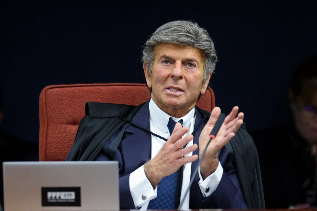 Uma palavra pode mudar o destino de dezenas de pessoas — e foi exatamente isso que aconteceu quando um voto trouxe de volta uma pergunta que parecia encerrada: as condenações do **8 de janeiro** foram mesmo justas? Por que esse movimento chama tanta atenção agora? Porque não se trata apenas de revisar números ou ajustar detalhes técnicos. O que entrou em discussão foi algo muito mais sensível: a possibilidade de que decisões já tomadas tenham, nas palavras do próprio ministro, **“incorrido em injustiças”**. E quando essa expressão aparece dentro do **STF**, a leitura do caso muda imediatamente. Mas o que, de fato, está sendo questionado? A base das condenações de parte dos réus. A dúvida central é se todos deveriam ter recebido o mesmo enquadramento, com o mesmo peso, diante de condutas que podem não ter sido idênticas. Isso parece apenas jurídico? À primeira vista, sim. Só que há um ponto que quase passa despercebido: quando se admite que pode ter havido exagero ou generalização, o impacto vai muito além de um processo isolado. Então o voto foi para anular tudo? Não. E é aqui que muita gente se surpreende. O que foi defendido não é um apagamento completo das responsabilizações, mas uma **revisão** que pode levar, conforme o caso, à **absolvição** ou à **redução de penas**. Em outras palavras, o foco não está em negar os fatos já conhecidos, mas em discutir se a resposta dada a alguns deles foi proporcional. E por que isso importa tanto? Porque o debate toca no coração de qualquer julgamento: a diferença entre punir e punir corretamente. Se houve réus enquadrados de forma mais severa do que o necessário, a consequência não é apenas jurídica — é institucional. Afinal, quando um ministro afirma que a decisão anterior pode ter produzido injustiça, ele não está falando de um detalhe periférico. Está apontando para a necessidade de recalibrar a própria medida da culpa. Mas quem fez esse movimento? Foi o ministro **Luiz Fux**, do **Supremo Tribunal Federal**, ao votar para rever condenações de réus ligados aos atos de **8 de janeiro**. E esse é o ponto que muda toda a leitura do caso. Não se trata de uma crítica externa, nem de uma contestação feita fora do tribunal. A revisão parte de dentro da própria Corte, o que dá ao gesto um peso político e jurídico muito maior. O que exatamente Fux disse? Segundo a descrição do caso, ele afirmou que a decisão anterior **“incorreu em injustiças”**. Essa frase, por si só, já desloca o centro da discussão. Se houve injustiça, onde ela estaria? Na dosimetria? No enquadramento? Na forma como diferentes condutas foram tratadas sob uma mesma lógica? A resposta completa ainda depende do andamento do julgamento, mas o voto já acende uma dúvida impossível de ignorar. E o que acontece depois disso? É aí que o cenário fica ainda mais delicado. Um voto como esse não reescreve sozinho todo o caso, mas abre espaço para uma reavaliação concreta de situações específicas. E quando uma porta dessas se abre, surge outra pergunta inevitável: quantos réus podem ser alcançados por esse entendimento? Mas há um detalhe que quase ninguém percebe: rever condenações não significa enfraquecer a gravidade do episódio. Significa, antes, separar com mais precisão quem fez o quê e qual deve ser a consequência exata para cada conduta. Essa distinção, que parece técnica, é justamente o que pode redefinir o rumo de vários processos. Então o ponto principal é a mudança de pena? Em parte. Só que o efeito mais profundo talvez esteja em outro lugar: no reconhecimento de que a Justiça, mesmo depois de decidir, ainda pode ser chamada a corrigir a si mesma. E isso recoloca tudo sob nova luz. No fim, o voto de **Fux** não apenas propõe **absolver ou reduzir penas** de réus do **8 de janeiro**. Ele lança uma pergunta que continua ecoando: se houve injustiça em algumas condenações, o que mais ainda pode precisar ser revisto?