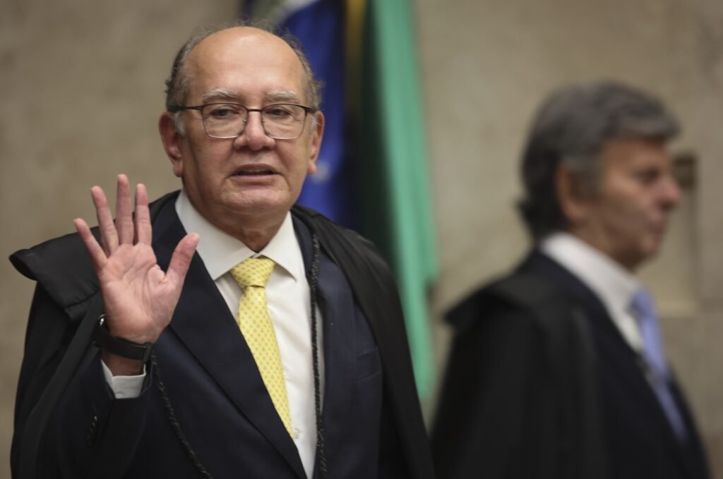 Uma defesa pública, feita no momento certo, reacendeu uma pergunta que parecia adormecida: por que a indicação de Jorge Messias ao STF passou a provocar tanta disputa antes mesmo de chegar ao plenário? A resposta começa com uma manifestação direta de Gilmar Mendes. O ministro do Supremo saiu em defesa do nome escolhido pelo presidente Luiz Inácio Lula da Silva e criticou o que chamou de “críticas vazias e apressadas”. Mas por que essa fala ganhou peso tão rapidamente? Porque ela não tratou apenas de uma opinião pessoal. Gilmar apontou que os críticos estariam ignorando o currículo e a experiência de Messias na administração pública. Disse ainda que o atual advogado-geral da União tem sólida formação acadêmica, trajetória técnica e credenciais para exercer a magistratura com equilíbrio, responsabilidade e senso institucional. Só que isso resolve a controvérsia? Ainda não. O que mantém o debate aceso é justamente o contraste entre a defesa feita por Gilmar e o histórico político e jurídico atribuído a Messias nos últimos anos. E é nesse ponto que muita gente começa a prestar mais atenção. Se a discussão fosse apenas sobre currículo, por que a reação seria tão intensa? A explicação está no papel que Messias ocupou em momentos decisivos. Ele trabalhou na Casa Civil durante o governo Dilma Rousseff, entre 2010 e 2016, e depois se tornou peça importante na equipe jurídica ligada à estratégia de anulação das condenações de Lula na Lava Jato, em 2018. Mas há um detalhe que quase passa despercebido: a controvérsia não fica presa ao passado. No governo atual, à frente da AGU, Messias coordenou ações para derrubar acordos de leniência que sustentavam provas contra figuras centrais do petismo e pressionou juridicamente empresas que colaboraram com a força-tarefa. Isso ampliou a percepção de que sua atuação ultrapassou a defesa institucional do Estado e entrou em terreno político. E quando esse ponto aparece, surge outra pergunta inevitável: como Gilmar responde a esse tipo de crítica? A resposta dele vai em outra direção. Para o ministro, a atuação de Messias também esteve ligada à defesa da soberania nacional. Gilmar citou a participação da AGU em processos no STF voltados à responsabilização de plataformas digitais por conteúdos ilícitos. É aqui que muita gente se surpreende, porque o mesmo conjunto de ações que gera resistência em alguns setores é apresentado, por seus defensores, como prova de preparo institucional. Mas o que acontece depois muda o foco da discussão. A indicação agora entra numa fase em que o discurso público deixa de ser suficiente. O nome de Messias será analisado pelo Senado nas próximas semanas, e a Comissão de Constituição e Justiça marcou a sabatina para 29 de abril. Antes disso, o relator, senador Weverton Rocha, deve apresentar parecer. Depois, a decisão vai ao plenário. E por que essa etapa é tão decisiva? Porque, para assumir a vaga no STF, Messias precisa de ao menos 41 votos favoráveis, em votação secreta. Isso significa que o apoio visível nem sempre revela o resultado real. E há mais um ponto que ajuda a entender o tamanho da disputa: o nome foi enviado ao Congresso cerca de quatro meses depois do anúncio da escolha, em meio a divergências políticas. Quais divergências? Houve resistência do senador Davi Alcolumbre, que defendia a indicação de Rodrigo Pacheco para a vaga. Nesse intervalo, Messias se reuniu com cerca de 70 senadores em busca de apoio. Esse movimento mostra que a batalha não está apenas no campo jurídico ou simbólico. Ela também é política, voto a voto, conversa a conversa. E então surge a pergunta central: afinal, o que está realmente em jogo nessa defesa de Gilmar Mendes? Não é só a proteção de um indicado sob ataque. É a tentativa de consolidar a narrativa de que Jorge Messias reúne qualificação técnica suficiente para superar as críticas ao seu papel em episódios centrais do governo e do petismo. No fim, a defesa de Gilmar não encerra a polêmica — ela a reorganiza. De um lado, Messias é apresentado como nome preparado, experiente e institucionalmente sólido. De outro, seu histórico na Lava Jato, na AGU e nas disputas sobre conteúdo digital mantém a indicação sob tensão. O ponto principal aparece justamente aí: a vaga aberta com a saída de Luís Roberto Barroso não será preenchida apenas por um currículo, mas pelo peso político de tudo o que esse nome já representou — e ainda pode representar.