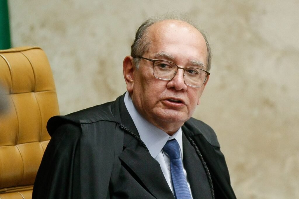 Uma viagem de poucas horas colocou o nome de **Gilmar Mendes** no centro de uma nova revelação. O que aconteceu? Segundo informações publicadas pelo jornal **O Estado de S. Paulo** e reproduzidas pela **Gazeta do Povo**, o decano do **Supremo Tribunal Federal**, o **STF**, viajou do **Mato Grosso** para **Brasília** em um avião de uma empresa que tinha **Daniel Vorcaro** como sócio. Quando essa viagem ocorreu? De acordo com o jornal, o deslocamento aconteceu em **1º de fevereiro de 2025**. Por que essa data chama atenção? Porque, ainda segundo a publicação, o voo ocorreu depois da posse de **Chico Mendes**, irmão de Gilmar, como prefeito de **Diamantino**, cidade apontada como reduto da família no estado. Mas como o ministro explicou essa viagem? Em resposta ao jornal, **Gilmar Mendes** afirmou que aceitou uma carona do empresário **Marcos Molina**. E onde ele foi acomodado? Em uma aeronave da **Prime You**, empresa que, conforme a reportagem, tinha **Daniel Vorcaro** em seu quadro societário. O que é a **Prime You** nesse contexto? A empresa aparece novamente porque é a mesma companhia de compartilhamento de jatos ligada ao voo em que viajou o deputado **Nikolas Ferreira**, do **PL de Minas Gerais**, segundo reportagem da coluna da jornalista **Malu Gaspar**, no jornal **O Globo**. E o que Nikolas disse na ocasião? Na época, o deputado declarou que não tinha como saber que **Vorcaro** seria acusado de crimes no futuro. Houve confirmação da viagem? Sim. A própria **Prime You** confirmou ao **Estadão** que o voo aconteceu. A empresa acrescentou algum esclarecimento? Sim. Ela negou que houvesse relação pessoal entre **Marcos Molina** e **Daniel Vorcaro**. Por que esse episódio ganhou dimensão maior? Porque, com a inclusão de **Gilmar Mendes**, passam a ser **quatro dos dez ministros da atual composição do STF** acusados de viajar em jatos ligados ao chamado **escândalo do Master**. Quem fez essa associação? Essa informação consta na reportagem citada pela **Gazeta do Povo**. O **STF** se manifestou oficialmente sobre o caso? Até o momento mencionado na publicação, não. A reportagem informou que entrou em contato com a assessoria do tribunal, mas não obteve resposta. Isso encerra o assunto? Não. O espaço, segundo o veículo, segue aberto para qualquer manifestação. Então, qual é o quadro descrito até aqui? Há o registro de uma viagem feita por **Gilmar Mendes** entre **Mato Grosso** e **Brasília**, em **1º de fevereiro de 2025**, após a posse de **Chico Mendes** em **Diamantino**. Há também a explicação do ministro de que aceitou uma carona de **Marcos Molina**. E há a identificação da aeronave como pertencente à **Prime You**, empresa que tinha **Daniel Vorcaro** como sócio, além da confirmação do voo pela própria companhia e da negativa de vínculo pessoal entre **Molina** e **Vorcaro**. O que permanece como dado central dessa notícia? Que o ministro **Gilmar Mendes** viajou em um avião da **Prime You** no dia **1º de fevereiro de 2025**, em trajeto do **Mato Grosso** para **Brasília**, após a posse de seu irmão **Chico Mendes** como prefeito de **Diamantino**, e que essa empresa tinha **Daniel Vorcaro** em seu quadro societário.