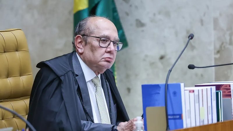 Uma votação no Supremo reacendeu uma disputa que vai muito além de uma lei estadual — e o primeiro movimento já mudou o rumo do debate. Mas o que exatamente está em jogo? À primeira vista, parece apenas mais uma discussão jurídica sobre regras de acesso ao ensino público. Só que, quando um ministro da mais alta Corte do país decide se manifestar contra uma norma recém-aprovada, a pergunta inevitável aparece: por que esse caso ganhou tanto peso? A resposta começa no conteúdo da própria lei. Ela restringiu a reserva de vagas em instituições de ensino que recebem verbas públicas, permitindo cotas apenas para pessoas com deficiência, estudantes vindos de escolas públicas ou critérios exclusivamente econômicos. E então surge a dúvida que empurra a discussão adiante: se essas hipóteses continuaram válidas, por que a controvérsia explodiu? Porque houve uma exclusão específica — e é justamente aí que o debate se torna mais sensível. A norma deixou de fora a reserva de cotas raciais. Isso fez com que partidos políticos e a OAB levassem o caso ao Supremo, sustentando que a medida contraria princípios já reconhecidos pela própria Corte. Mas há um ponto que quase passa despercebido: essa não foi a primeira reação institucional contra a lei. Antes mesmo de o tema chegar ao STF, a norma já havia sido suspensa por decisão liminar do Tribunal de Justiça de Santa Catarina. E por que isso importa tanto? Porque mostra que a disputa não nasceu apenas no campo político. Ela avançou rapidamente para o campo constitucional, onde a pergunta central deixou de ser apenas “o que a lei diz?” e passou a ser “ela pode dizer isso?”. É nesse momento que o voto de Gilmar Mendes ganha dimensão real. O ministro votou para derrubar a lei de Santa Catarina e afirmou que o Supremo já reconheceu a constitucionalidade, em abstrato, das ações afirmativas baseadas em critérios étnico-raciais. Em outras palavras, o argumento apresentado por ele não parte de uma novidade, mas de um entendimento que a Corte já consolidou. E é aqui que muita gente se surpreende: o centro da discussão não está apenas na criação de cotas, mas na tentativa de impedir uma modalidade que o STF já considerou compatível com a Constituição. Então isso significa que o caso está encerrado? Ainda não. E o que acontece depois pode mudar tudo. O julgamento ocorre no plenário virtual e segue aberto até o dia 17, com a expectativa de que outros ministros também apresentem seus votos. Mais nove ainda vão se manifestar. Ou seja, embora o voto de Gilmar Mendes tenha forte peso político e jurídico, o desfecho formal ainda depende da posição do restante da Corte. Mas por que esse julgamento chama tanta atenção agora? Porque ele toca em um tema que nunca deixa de provocar reação: o papel das ações afirmativas na inclusão social. Ao defender a anulação da lei, Gilmar Mendes reforçou justamente esse ponto, destacando a importância dessas políticas. E isso puxa outra pergunta, talvez a mais incômoda de todas: quando uma lei estadual limita cotas a critérios econômicos, escolares e de deficiência, mas exclui o recorte racial, ela está reorganizando prioridades ou esvaziando uma política pública já legitimada? Essa é a questão que paira sobre o julgamento. A lei foi aprovada pela Assembleia Legislativa de Santa Catarina e sancionada pelo governador Jorginho Melo. Só que, ao chegar ao Supremo por ações apresentadas por PSOL, PT, PCdoB e pelo Conselho Federal da OAB, ela deixou de ser apenas uma escolha legislativa local. Passou a ser testada diante da Constituição. E o detalhe mais importante talvez esteja justamente aí: o voto já apresentado não discute apenas Santa Catarina. Ele sinaliza como o Supremo pode reagir quando uma norma tenta afastar cotas raciais de instituições públicas de ensino financiadas pelo Estado. O julgamento continua, os demais votos ainda não foram conhecidos, e é exatamente por isso que o caso segue aberto — não só no tribunal, mas no centro de uma discussão que ainda está longe de perder força.