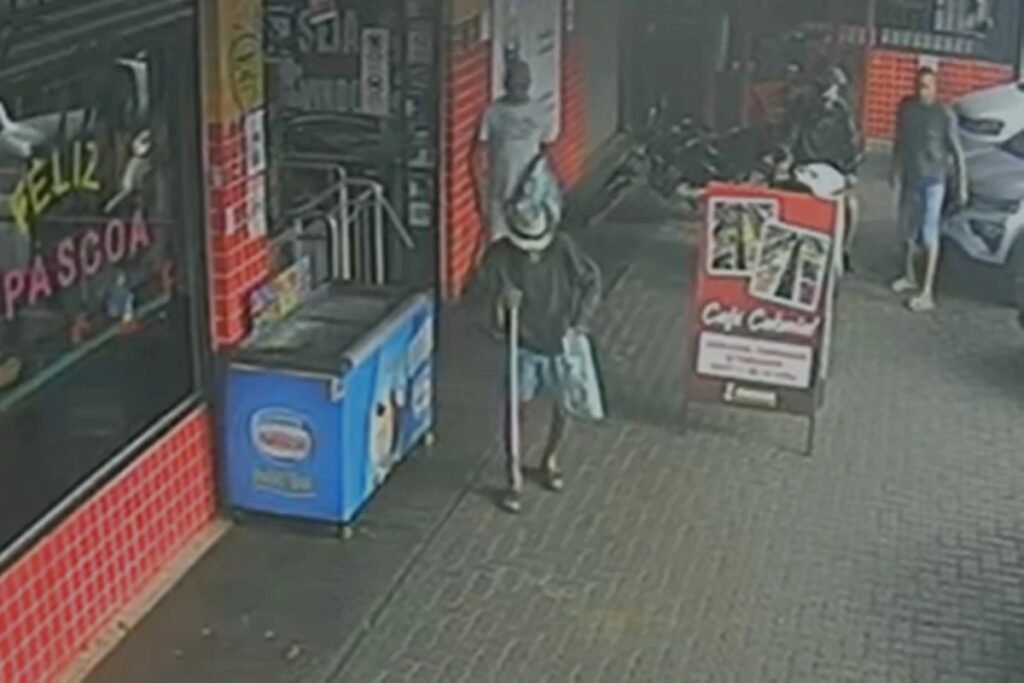 O que aconteceu em Ceilândia com um idoso de 92 anos? Um idoso de 92 anos foi atingido no rosto por uma garrafa de vidro arremessada por um homem de 63 anos na QNN 8 de Ceilândia, DF. Como o incidente foi registrado? Uma câmera de segurança capturou o momento em que o idoso, usando uma bengala, sai de um estabelecimento e é atingido pela garrafa. Qual foi a reação das pessoas no local? Populares tentaram agredir o agressor, mas foram contidos pela polícia, que chegou rapidamente ao local. Qual foi a condição do agressor no momento do ataque? O homem apresentava sinais de estar sob efeito de substâncias entorpecentes, segundo a PMDF. Como foi o atendimento à vítima? O Corpo de Bombeiros prestou atendimento ao idoso, que foi encaminhado para uma unidade hospitalar. Qual foi o desdobramento policial do caso? A ocorrência foi registrada na 15ª Delegacia de Polícia em Ceilândia Centro para investigação. Por que esse incidente gerou tanta revolta? A agressão a um idoso indefeso causou indignação, levando populares a tentarem fazer justiça com as próprias mãos. O que pode ser feito para evitar casos semelhantes? Aumentar a segurança e o monitoramento em áreas públicas pode ajudar a prevenir incidentes como este.