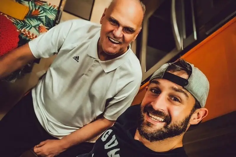 A dor cabe em poucas palavras quando ela é grande demais? Às vezes, sim. E foi justamente uma expressão curta, direta e devastadora que resumiu um luto impossível de medir: **“sem chão”**. Mas por que essa frase tocou tanta gente de forma tão imediata? Porque ela não veio como um comunicado frio, nem como uma despedida distante. Veio como um rasgo emocional de alguém que, antes de qualquer coisa, estava vivendo o peso de perder o próprio pai. E é nesse ponto que tudo ganha outra dimensão: não se trata apenas da morte de um nome conhecido, mas da queda de uma referência íntima, insubstituível. Quem falou isso e em que contexto? A declaração foi feita por **Felipe**, filho de **Oscar Schmidt**, logo após a confirmação da morte do ex-jogador de basquete, nesta sexta-feira, **17/4**. Em uma publicação nas redes sociais, ele transformou a própria dor em palavras que muita gente reconhece, mas quase ninguém consegue explicar com precisão. O que exatamente ele disse? Felipe começou com uma frase que já mostra o tamanho da perda em duas escalas diferentes: **“Um ídolo para o mundo e para mim. Hoje o mundo perde um ídolo, e eu perco meu pai.”** A partir daí, o desabafo ficou ainda mais íntimo. Ele afirmou que aquele não estava sendo um dia fácil e admitiu algo que muita gente só entende quando vive: a dor de perder pai ou mãe é, de fato, **inexplicável**. Mas há um detalhe que quase ninguém percebe de imediato: o texto não fala apenas sobre ausência. Ele fala sobre o que a ausência faz por dentro. Felipe descreveu o luto como a criação de um **vazio**, a sensação de ficar **sem chão**, como se **um pedaço de você fosse arrancado**. E é justamente essa imagem que prende a atenção, porque ela não tenta enfeitar a dor. Ela mostra a dor como ela chega. E o que acontece depois muda tudo, porque o desabafo não ficou apenas no impacto da perda. Mesmo em meio ao sofrimento, Felipe também falou sobre o tempo. Disse que **o tempo cura tudo**, que a dor vai ficar mais fácil de lidar, embora **nunca vá sair completamente**. Essa passagem chama atenção por um motivo simples: ela não nega o sofrimento, mas também não transforma o luto em um ponto final absoluto. Então a mensagem foi só de tristeza? Não. E é aqui que muita gente se surpreende. Em meio ao pedido por respeito, Felipe também fez um apelo para que a vida do pai fosse **celebrada**. Ele pediu que sua família pudesse viver o luto, mas também destacou que o pai deve ser lembrado pelo que construiu **dentro e fora das quadras**. Ao chamá-lo de **herói**, ele não falou apenas como filho, mas como alguém que reconhece o tamanho do legado deixado. Que legado é esse? No texto, Felipe afirma que Oscar Schmidt deixou no **basquete** uma marca que **poucos alcançaram**. E essa frase ganha ainda mais força porque vem no mesmo momento em que ele separa duas figuras que, ali, se misturam o tempo todo: o ídolo público e o pai privado. Quanto maior o nome, maior parece o contraste com a intimidade da despedida. Mas o trecho mais forte ainda estava por vir. O filho escreveu que vai sentir falta do pai e que pretende **honrar tudo o que aprendeu com ele como homem**. Disse ainda que tentará ser ao menos **10% do ser humano** que o pai foi. O peso dessa frase está justamente no que ela revela sem precisar explicar demais: a influência de Oscar Schmidt não terminou na carreira, nem nas homenagens, nem na imagem pública. Ela continuou dentro de casa, na formação do filho. E como essa despedida termina? Com uma frase que fecha o texto, mas não encerra a emoção: **“Agora descansa em paz, pai. Dá um oi para a nossa nona. Você está no hall da fama da vida.”** É uma despedida que mistura dor, memória, afeto e reverência. E talvez seja por isso que ela tenha repercutido tanto: porque, no fim, não foi apenas sobre a morte de **Oscar Schmidt**, aos **68 anos**. Foi sobre o instante em que um filho precisou resumir o impossível — e, ao fazer isso, deixou no ar uma pergunta que continua ecoando: como seguir em frente quando quem era chão também vira saudade?