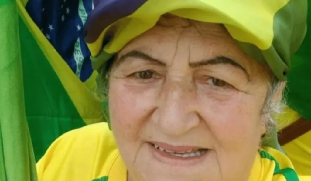 A decisão saiu e mexe com um dos rostos mais conhecidos do 8 de Janeiro. Quem teve a prisão domiciliar autorizada? Fátima de Tubarão. Quem é ela nesse caso? Trata-se de Fátima Mendonça Jacinto Souza, condenada pelos atos de 8 de janeiro de 2023. Quem autorizou a mudança? O ministro Alexandre de Moraes, do STF. Ela foi a única beneficiada? Não. Segundo a ASFAC e a ativista Pérula Tuon, pelo menos 18 idosos presos pelos atos receberam o mesmo benefício. Qual é a faixa etária desses condenados? As idades vão de 61 a 74 anos. A decisão significa liberdade plena? Não. A prisão domiciliar veio acompanhada de uma série de restrições. Quais restrições foram impostas? Eles não poderão sair do país. Também não poderão usar redes sociais. Há outra limitação importante? Sim. Os beneficiados não poderão se comunicar com outros envolvidos no 8 de Janeiro. E sobre visitas? As visitas ficam restritas à defesa e à família. Existe monitoramento? Sim. Os condenados terão de usar tornozeleira eletrônica. Há outra medida cautelar? Sim. Os passaportes foram suspensos. Qual era a situação penal desses idosos? Eles cumprem penas que variam de 13 a 17 anos de prisão. E no caso de Fátima de Tubarão? Ela foi condenada a 17 anos. Quando saiu essa condenação? Em agosto de 2024. Por quais crimes ela foi condenada? Golpe de Estado. Associação criminosa armada. Dano qualificado. Abolição violenta do Estado Democrático de Direito. E deterioração de patrimônio tombado. Por que o nome dela ganhou tanta repercussão? Porque ela apareceu em vídeo durante os atos. O que foi registrado nesse vídeo? Ela dizia estar “quebrando tudo”. E fez referência a quem? Ao ministro Alexandre de Moraes. Qual foi a frase citada? Ela disse que “pegaria o Xandão”. Como ela se defendeu na Justiça? Confirmou que esteve nos atos. Mas alegou que não tinha o objetivo de incitar violência com frases como “vamos para a guerra”. O que torna a decisão ainda mais sensível? O momento em que ela foi tomada. Por quê? Porque saiu menos de uma semana antes da sessão do Congresso Nacional que vai analisar o veto de Lula ao PL da Dosimetria. O que propõe esse projeto? A redução de penas para presos do 8 de Janeiro e para envolvidos em tentativa de golpe de Estado. Esse detalhe muda a leitura política do caso? No mínimo, aumenta a pressão sobre um tema já explosivo. Por quê? Porque o debate sobre penas, prisão e proporcionalidade volta ao centro da disputa. O que aconteceu em 8 de janeiro de 2023? Manifestantes favoráveis ao ex-presidente Jair Bolsonaro invadiram e depredaram as sedes dos Três Poderes, em Brasília. Como a mobilização começou? Inicialmente, como protesto contra a posse de Lula, eleito em 2022. E no que se transformou? Em um ataque às instituições. O que aconteceu depois? O STF iniciou o julgamento das ações penais conduzidas por Alexandre de Moraes. Qual foi o saldo desses processos até agora? Mais de 800 condenações. Houve absolvições? Sim. Foram 14 absolvições. E há foragidos? Sim. O texto cita dezenas de foragidos. Quantas pessoas condenadas estavam presas até janeiro deste ano? Segundo dados do gabinete de Moraes divulgados pela CNN, 158 das 835 condenadas. Isso representa quanto? Cerca de 19 por cento do total. O que aconteceu com parte dos demais réus? Metade teve a pena de prisão convertida em prestação de serviços comunitários. E os que seguiram em reclusão? Segundo o texto, a maioria aguarda o desfecho do processo em liberdade. Há outros catarinenses entre os condenados? Sim. Além de Fátima de Tubarão, ao menos outros seis catarinenses aparecem na lista. Algum detalhe chama atenção nesse grupo? Sim. Três romperam a tornozeleira eletrônica e fugiram para a Argentina, em maio de 2024. Onde eles estão agora? Atualmente, não há informação sobre o paradeiro deles. Então qual é o ponto central dessa nova decisão? Fátima de Tubarão, condenada a 17 anos, está entre os 18 idosos do 8 de Janeiro que tiveram a prisão domiciliar autorizada por Alexandre de Moraes. Isso encerra o caso? Não. A condenação permanece. As restrições continuam severas. E o debate sobre penas, critérios e timing político só ganha mais força.