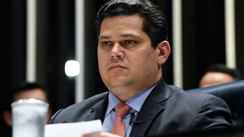 Bastou uma fala atravessar o limite entre crítica e **ameaça** para o Senado ser empurrado ao centro de uma crise que ninguém conseguiu mais ignorar. Mas o que, de fato, fez a pressão explodir tão rápido? Tudo começou quando senadores de diferentes partidos passaram a cobrar uma reação firme da presidência da Casa. A cobrança não veio por um detalhe protocolar, nem por uma divergência comum entre instituições. Veio porque um parlamentar afirmou ter sido alvo de intimidação por causa de um ato praticado no exercício do mandato. E quando isso acontece, a pergunta deixa de ser apenas política: até onde vai a proteção das **prerrogativas parlamentares**? E por que esse ponto ganhou tanta força? Porque o argumento apresentado foi direto: um senador disse estar sendo **ameaçado e criminalizado por um voto**. A declaração elevou o tom do debate e arrastou outros colegas para o mesmo campo de preocupação. Se um voto dado no âmbito de uma comissão pode gerar reação com potencial de punição, o que isso significa para a atuação de qualquer outro senador? É aqui que muita gente começa a perceber que o caso não ficou restrito a um embate pessoal. Mas quem entrou nessa disputa e por quê? O centro da tensão foi o relatório final da **CPI do Crime Organizado**. Nele, o relator, **Alessandro Vieira**, pediu o indiciamento de três ministros do **STF** — **Dias Toffoli, Alexandre de Moraes e Gilmar Mendes** — além do procurador-geral da República, **Paulo Gonet**. A partir daí, o ambiente mudou. Segundo Vieira, manifestações de ministros ocorreram enquanto o colegiado ainda analisava o relatório. E isso abriu uma dúvida ainda mais sensível: houve apenas reação pública ou algo que ultrapassou o direito de resposta? A resposta dada por Vieira foi dura. Ele afirmou que as declarações extrapolaram esse limite e apontou **risco institucional** quando integrantes da Corte ameaçam parlamentares no exercício do mandato. A fala acendeu um alerta dentro do Senado, porque o debate deixou de ser sobre concordar ou discordar do relatório. Passou a ser sobre a liberdade de um senador para se manifestar sem sofrer retaliação. Mas há um detalhe que quase ninguém percebe de imediato: mesmo quem discordou do conteúdo do relatório acabou defendendo esse princípio. E quem fez isso? Um dos exemplos foi **Randolfe Rodrigues**, líder do governo no Congresso. Ele disse discordar do relatório, mas defendeu as prerrogativas parlamentares e afirmou que ministros têm direito de se manifestar, não de ameaçar senadores. Esse ponto mudou o peso político do episódio. Quando a defesa da **inviolabilidade de opiniões, palavras e votos** ultrapassa a oposição e alcança outros campos, a crise deixa de ser localizada. O que acontece depois muda tudo: a pressão sobre a presidência do Senado se torna inevitável. Foi nesse cenário que **Davi Alcolumbre** reagiu. Pressionado por senadores de diferentes partidos, o presidente do Senado afirmou que a **Advocacia do Senado** está à disposição dos congressistas para adotar medidas jurídicas em defesa das prerrogativas da Casa. Segundo ele, o órgão poderá atuar para garantir a **legitimidade do voto popular** e a atuação dos senadores no exercício do mandato. Parece uma resposta institucional, mas a dúvida seguinte surge sozinha: isso basta para conter a escalada? Talvez não, porque outros senadores ampliaram o tom. **Flávio Bolsonaro** falou em **desequilíbrio entre os Poderes** e disse também ter sido alvo de ameaças no STF. **Magno Malta** cobrou manifestação institucional junto ao presidente da Corte, **Edson Fachin**, e aos ministros citados. **Marcos do Val** falou em escalada de tensão entre Congresso e Judiciário. **Cleitinho** defendeu medidas mais duras, incluindo pedidos de impeachment. **Eduardo Girão** manifestou apoio ao relator e elogiou o trabalho da CPI. E é aqui que a maioria se surpreende: a reação não ficou concentrada em um único grupo, mas se espalhou por diferentes partidos e discursos. Só que havia mais um movimento em curso. No mesmo dia, **Gilmar Mendes** encaminhou à **PGR** uma representação contra Alessandro Vieira, pedindo investigação por suposto **abuso de autoridade**. O ministro argumenta que houve **desvio de finalidade** na atuação do senador como relator da CPI. E esse é o ponto que fecha o círculo sem encerrar a tensão: uma eventual condenação pode tornar Vieira **inelegível** para as eleições de outubro. Então qual é o núcleo real dessa história? Não é apenas o apoio oferecido por Alcolumbre. É o fato de que esse apoio surgiu depois de uma pressão aberta do Senado diante da percepção de que um parlamentar pode estar sob ameaça por causa de um voto. A resposta institucional foi dada, mas a pergunta que continua no ar é a que mais pesa: quando a defesa das prerrogativas precisa ser acionada contra reações vindas do próprio topo do sistema, quem ainda consegue dizer onde esse conflito realmente termina?