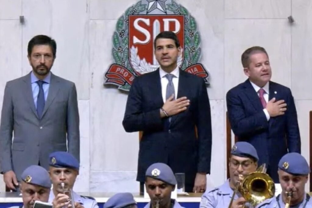 Em meio à disputa por uma vaga no **STF**, um gesto chamou atenção em São Paulo e abriu uma nova camada do cenário político. Quem apareceu em um evento de homenagem a **André Mendonça** foi justamente **Jorge Messias**, o **advogado-geral da União** indicado por **Lula** para integrar a Corte. Mas o que exatamente aconteceu? Nesta segunda-feira, **6 de abril**, Messias compareceu à **Assembleia Legislativa de São Paulo**, a **Alesp**, onde Mendonça recebeu o **Colar da Honra ao Mérito Legislativo**. A homenagem foi proposta pelo deputado estadual **Oseias de Madureira**, do **PL**, descrito como evangélico, assim como o ministro. Por que a presença de Messias teve peso político? Porque ele não foi apenas mais uma autoridade entre os convidados. Hoje, como **AGU**, ele aguarda os próximos passos no **Senado** para tentar viabilizar sua chegada ao Supremo. Depois de ter o nome enviado por Lula, depende agora de o presidente da Casa, **Davi Alcolumbre**, pautar a **sabatina** e a votação em plenário. E quem mais estava na solenidade? O encontro reuniu diversas autoridades. Estiveram presentes o governador **Tarcísio de Freitas**, do **Republicanos**, o prefeito da capital **Ricardo Nunes**, do **MDB**, o presidente da **Alesp**, **André do Prado**, do **PL**, e o presidente do **Tribunal de Justiça de São Paulo**, o desembargador **Francisco Eduardo Loureiro**. A sessão, assim, contou com representantes dos principais poderes paulistas. O que Mendonça disse diante de Messias? Em seu discurso, o ministro destacou a presença do atual AGU e afirmou que a passagem de ambos pela **Advocacia-Geral da União** foi um **“divisor de águas”** em suas carreiras. Mendonça ocupou o cargo no governo de **Jair Bolsonaro**, enquanto Messias exerce a função no governo **Lula**. Houve alguma fala direta sobre o futuro de Messias? Sim. Mendonça foi explícito ao se dirigir a ele: **“Faço votos que em breve você possa deixar a AGU para estar comigo no Supremo Tribunal Federal”**. A declaração ocorreu justamente no momento em que o nome de Messias ainda depende da tramitação no Senado. E por que essa indicação ainda não avançou? A oficialização do nome de Messias foi adiada por Lula em meio a uma tensão com **Alcolumbre**. O presidente do Senado preferia o nome do senador **Rodrigo Pacheco** para a vaga. Mesmo com a indicação já feita, o avanço do processo ainda passa pela articulação política na Casa. Qual é o contexto de André Mendonça nesse momento? O ministro está sob os holofotes por atuar como relator de casos citados como dois dos maiores escândalos do país: o caso **Master** e o caso do **INSS**. Como foi indicado ao Supremo por Bolsonaro, suas decisões nesses episódios vêm sendo capitalizadas por bolsonaristas. De que forma isso tem ocorrido? As investigações sob sua relatoria têm sido usadas por esse grupo para atacar dois alvos centrais: o ministro **Alexandre de Moraes** e o presidente **Lula**. Entre as decisões recentes de Mendonça mencionadas nesse contexto estão a prisão do banqueiro **Daniel Vorcaro** e a quebra dos sigilos bancário e fiscal de **Lulinha**. Então, o que ficou marcado nesse encontro? Em plena espera pela sabatina no Senado, **Jorge Messias**, indicado por **Lula** ao **STF**, esteve na **Alesp** na homenagem a **André Mendonça**, ouviu do ministro que espera vê-lo em breve no Supremo e participou de uma solenidade que reuniu **Tarcísio de Freitas**, **Ricardo Nunes**, **André do Prado** e **Francisco Eduardo Loureiro**, enquanto sua aprovação segue dependendo de **Davi Alcolumbre** pautar a sabatina e a votação no plenário do Senado.