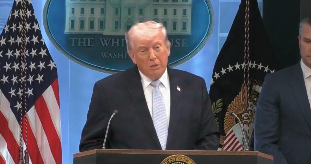 Bastou uma frase para acender o alerta: **“o país inteiro pode cair em uma noite”**. Quem disse isso? **Donald Trump**, durante uma coletiva na segunda-feira, dia **6**, ao falar sobre o **Irã** e indicar a possibilidade de uma nova ofensiva contra **Teerã** no curto prazo. Mas essa declaração surgiu isolada, sem contexto? Não. Ela veio acompanhada de comentários sobre uma operação militar que, segundo o presidente dos Estados Unidos, terminou sem mortes entre os militares americanos envolvidos. Que operação foi essa? O resgate da tripulação de um **caça F-15E** abatido em **3 de abril**. E o que houve com os tripulantes? Trump afirmou que as forças norte-americanas conseguiram resgatar o segundo tripulante no **domingo de Páscoa, 5**. Por que esse resgate chamou tanta atenção? Porque, segundo ele, a missão exigiu a mobilização de **155 aeronaves**. Como esse militar ficou para trás? O **oficial de sistemas de armas** se ejetou e caiu longe do piloto. O que aconteceu depois? Ele passou **dois dias escondido em território iraniano**. E em que condições? Durante esse período, sofreu ferimentos e tentou evitar a captura. De que forma ele conseguiu sobreviver? Trump relatou que o militar percorreu áreas montanhosas enquanto forças locais e civis buscavam sua localização. Ele escalou montanhas mesmo **sangrando**. E onde se abrigou? Em uma **caverna**, onde permaneceu escondido, segurando uma arma e aguardando o resgate. Como os americanos conseguiram encontrá-lo? Segundo Trump, o militar conseguiu transmitir **sinais** que permitiram localizar sua posição e realizar a retirada. O presidente resumiu a operação com uma frase direta: **“Nós movemos céus e terras para trazê-los. Deus estava olhando para nós.”** A missão ocorreu sem obstáculos adicionais? Não, segundo o próprio Trump. O presidente afirmou que um **vazamento de informações da CIA** dificultou a operação. O que teria vazado? De acordo com ele, o governo não pretendia divulgar a presença de um segundo militar em solo iraniano. E por que isso seria tão grave? Porque, ainda segundo Trump, a informação chegou à imprensa e teria alcançado autoridades locais. Qual foi a reação dele? O presidente declarou que o responsável pelo vazamento será **identificado e punido**. Esse episódio foi tratado como um caso isolado? Também não. Trump citou a intensidade das operações recentes conduzidas pelos Estados Unidos. Quais números ele apresentou? Nos últimos **37 dias**, as forças norte-americanas realizaram mais de **10 mil voos** e atingiram mais de **13 mil alvos**. Então a fala sobre o Irã foi apenas retórica? A declaração foi feita justamente ao indicar a possibilidade de uma nova ofensiva em prazo curto. O que ele disse, exatamente? Que **“o país [Irã] inteiro pode cair em uma noite e isso pode acontecer amanhã”**. Houve mais detalhes sobre a operação de resgate? Sim. Em uma fala reproduzida publicamente, Trump afirmou: **“The second rescue mission involved 155 aircraft… We were bringing them all over, and a lot of it was subterfuge. We wanted to have them think he was in a different location because they had a vast military force out there. Thousands of people were looking.”** Em português, a declaração indica que a segunda missão de resgate envolveu **155 aeronaves**, com uso de **subterfúgio** para fazer o outro lado acreditar que o militar estava em uma localização diferente, enquanto **milhares de pessoas** o procuravam. E o que permanece como ponto mais sensível de toda a coletiva? A combinação entre a ameaça direta ao **Irã**, o relato de uma operação de grande escala em território iraniano e a acusação de que um vazamento comprometeu a segurança da missão. No centro de tudo ficou a frase que abriu a coletiva e concentrou a atenção: **“o país [Irã] inteiro pode cair em uma noite e isso pode acontecer amanhã”**.