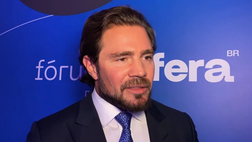 Uma decisão nos **Estados Unidos** abriu caminho para rastrear possíveis bens do **Banco Master** fora do Brasil — e o alcance dessa apuração vai além do que parecia à primeira vista. O que exatamente foi autorizado? O **Tribunal de Falências do Distrito Sul da Flórida** deu aval à liquidante do banco, a **EFB Regimes Especiais de Empresas**, para investigar ativos da instituição no exterior. A medida foi confirmada pelo juiz **Scott Grossman**, que manteve **24 dos 28 requerimentos** apresentados entre **29 de janeiro e 19 de fevereiro de 2026**. Mas que tipo de investigação é essa? A autorização permite a coleta de informações junto a **galerias de arte**, **varejistas de luxo**, **casas de leilão** e também ao banqueiro **Daniel Vorcaro**. A intenção é mapear bens que possam ter sido mantidos fora do alcance das autoridades ou transferidos de forma a dificultar sua identificação. Por que esses alvos entraram no radar? Porque, segundo a decisão, as intimações miram **“negociantes de arte, varejistas de luxo e outros”** em relação não apenas aos devedores, mas também a **outras dezesseis entidades**, entre elas o próprio **Vorcaro**, classificadas como **“Partes de Congelamento de Ativos”**. E o que a liquidante busca descobrir com isso? O objetivo da **EFB** é identificar ativos que possam ter sido **transferidos** ou **dissimulados**, além de examinar **transações financeiras** envolvendo **Daniel Vorcaro** e pessoas ou empresas ligadas a ele. A apuração, portanto, não se limita a bens em nome direto dos devedores, mas alcança relações patrimoniais que possam ter conexão com eles. Em que base o juiz sustentou essa autorização? **Scott Grossman** acolheu o argumento de que a **legislação brasileira** permite investigar controladores cujos patrimônios possam estar misturados aos ativos dos devedores. Na fundamentação, ele registrou que, **“sob a lei brasileira, essas partes estão sujeitas a uma ou mais ordens automáticas de congelamento de ativos inseridas pelo Banco Central do Brasil em conexão com a liquidação extrajudicial dos devedores”**. Houve contestação? Sim. A defesa de **Vorcaro** argumentou que as intimações seriam **genéricas** e sem foco definido. Ainda assim, o juiz concluiu que o banqueiro não demonstrou **“causa justa”** suficiente para barrá-las. Também entendeu que não foi explicado de forma concreta como direitos de **privacidade** se aplicariam ao caso. Isso significa que a investigação foi liberada sem limites? Não. Embora a maior parte dos pedidos tenha sido mantida, houve uma restrição importante. **Grossman** acolheu a chamada **“regra do processo pendente”**, que limita investigações amplas quando já existe um litígio formal em andamento sobre o mesmo objeto. E qual é esse ponto específico já judicializado? Trata-se de uma **mansão na Flórida avaliada em US$ 32 milhões**, relacionada a **Vorcaro**. Em **2 de março**, a **EFB** protocolou uma reclamação no mesmo tribunal contra a **Sozo Real Estate Inc.**, **Henrique M. Vorcaro**, pai do banqueiro, e **Natalia Vorcaro Zettel**, sua irmã, todos vinculados ao imóvel. O que muda, então, em relação a essa propriedade? A liquidante poderá produzir provas sobre a mansão, mas dentro de limites mais estreitos. Em vez de uma busca ampla e irrestrita, a apuração sobre esse bem deverá seguir parâmetros mais contidos, justamente porque o tema já está submetido a uma ação específica. E qual foi o fundamento usado nessa reclamação? A **EFB** invocou o conceito jurídico de **“constructive trust”**. Por esse mecanismo, uma pessoa que aparece como proprietária formal de um bem pode ser obrigada a transferi-lo ao verdadeiro beneficiário de direito. No fim, o que a decisão definiu com clareza? Que a investigação pode ser **ampla** quando se trata da busca por ativos em geral no exterior, inclusive com acesso a informações de setores como **arte** e **luxo**, além de dados ligados a **Daniel Vorcaro** e às **dezesseis entidades** enquadradas como **“Partes de Congelamento de Ativos”**. Ao mesmo tempo, no caso da **mansão de US$ 32 milhões na Flórida**, a produção de provas fica **circunscrita** ao processo já aberto contra **Sozo Real Estate Inc.**, **Henrique M. Vorcaro** e **Natalia Vorcaro Zettel**, com base na tese de **constructive trust**.