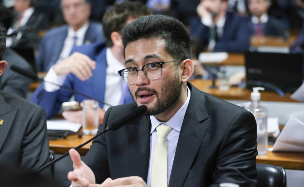 Uma proposta apresentada em Brasília quer mexer em um dos pontos mais sensíveis do sistema prisional: e se a recusa de um preso em trabalhar pudesse dobrar o tempo que ainda falta da pena? Parece exagero à primeira vista? Então a pergunta inevitável é outra: isso seria apenas uma fala política de efeito ou já existe um texto formal com consequências bem definidas? A resposta é que se trata de um projeto de lei protocolado na Câmara dos Deputados, com mudanças previstas no Código Penal e na Lei de Execução Penal. Mas o que exatamente mudaria na prática? Segundo a proposta, o trabalho do preso passaria a ser obrigatório, exceto quando houver impedimento de saúde. E não se trata apenas de uma recomendação simbólica. A recusa, seja expressa ou até tácita, teria efeito direto sobre a pena remanescente. E o que significa isso de forma objetiva? Significa que, se o preso se recusar a trabalhar, o tempo restante da pena seria dobrado. Só isso já chama atenção, mas há um ponto que quase passa despercebido quando o tema surge no debate público: a proposta também bloqueia benefícios importantes da execução penal. Quais benefícios seriam afetados? O texto prevê que quem se recusar a trabalhar ficaria impedido de obter progressão de regime, livramento condicional e até o direito à frequência em curso supletivo profissionalizante. E é justamente aqui que muita gente para e pensa: então o projeto não trata apenas de trabalho, mas de toda a lógica de cumprimento da pena. Mas há um detalhe que quase ninguém percebe de imediato: o projeto também mexe no destino do dinheiro recebido pelo preso. Se o trabalho for remunerado, o valor não ficaria livremente com ele. A proposta estabelece que essa quantia seja destinada à vítima do crime, até que a reparação esteja completa. Isso muda o foco da discussão? Em parte, sim. Porque a pergunta deixa de ser apenas se o preso deve ou não trabalhar e passa a ser outra: o trabalho serviria como forma de punição, de disciplina ou de reparação? Pelo texto, a prioridade na atribuição do trabalho deve considerar primeiro a necessidade de reparar a vítima. Só depois entram fatores como habilitação, condição pessoal, necessidades futuras do preso e oportunidades oferecidas pelo mercado. Então de onde veio essa proposta? Ela foi protocolada pelo deputado federal Kim Kataguiri, do União Brasil de São Paulo, nesta segunda-feira, 13. E o argumento apresentado por ele é direto: o Brasil vive uma crise de segurança em que, segundo sua justificativa, o trabalhador honesto paga a conta enquanto o sistema trata o criminoso com excessiva complacência. Mas por que esse projeto tende a gerar tanta reação? Porque ele toca em uma divisão profunda do debate público. De um lado, a ideia de endurecimento penal com tolerância zero. De outro, a discussão sobre os limites legais e práticos de tornar o trabalho obrigatório dentro do sistema prisional. E o que acontece depois pode mudar toda a leitura da proposta: ela ainda não virou lei. Em que estágio ela está agora? O texto aguarda a definição da Mesa Diretora da Câmara sobre por quais comissões vai tramitar. Só depois disso começará o caminho formal de análise legislativa. E é aqui que a maioria se surpreende: apesar do impacto da proposta, tudo ainda depende da tramitação, dos pareceres e das votações. Quando isso passaria a valer, se fosse aprovado? O projeto prevê entrada em vigor 30 dias após a publicação no Diário Oficial da União. Parece simples, mas essa previsão só conta se todo o percurso legislativo for concluído. E qual é o ponto central de tudo isso? A proposta tenta transformar a recusa ao trabalho em um fator de agravamento real da pena, ao mesmo tempo em que direciona a remuneração à vítima do crime. No papel, a mensagem é clara: fazer o preso trabalhar, restringir benefícios em caso de recusa e usar esse esforço como forma de reparação. Só que a discussão que isso abre está longe de terminar — porque, quando uma proposta promete dobrar pena e redefinir o sentido do trabalho prisional, a pergunta final nunca é apenas o que está escrito, mas até onde isso pode ir.