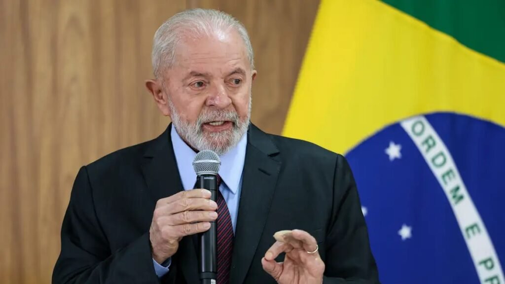 A disputa de **2026**, na fala de **Lula**, não começa como uma eleição comum, mas como uma nova batalha pela própria **democracia**. Por que o presidente colocou a próxima eleição nesse patamar? Porque, segundo ele, há uma tentativa da **direita brasileira** de dar continuidade ao que ocorreu em **8 de janeiro de 2023**. Em entrevista ao site **ICL**, Lula afirmou que existe um movimento para consolidar um **“esquema de ultra direita”** voltado contra políticas públicas democráticas e contra as instituições. Mas o que ele disse, exatamente, sobre esse risco? Lula declarou que há quem sonhe em **“fechar a Suprema Corte”**, fale em **“fraudes nas urnas eletrônicas”** e mantenha o hábito de **questionar as instituições**. Por isso, afirmou que as eleições voltarão a ser, em suas palavras, uma disputa para **“defender a democracia”**. Também disse que será necessário explicar novamente à sociedade o significado da democracia, como, segundo ele, já ocorreu em **2022**. E como essa avaliação se conecta ao governo atual? Lula retomou o argumento de que seu terceiro mandato encontrou o país em situação de **“terra arrasada”**. A partir dessa leitura, afirmou que passou **dois anos** reconstruindo políticas públicas que, em sua visão, teriam sido destruídas no governo de **Jair Bolsonaro**. Nesse contexto, voltou a dizer que **2026** será o **“ano da colheita”**, expressão que costuma repetir em seus discursos. Se ele fala em reeleição, como justifica a continuidade no cargo? Lula respondeu com uma pergunta: **“Pra que eu quero ou preciso de um quarto mandato?”**. Em seguida, afirmou que tem na cabeça a importância de dar um **“salto de qualidade”**. Segundo ele, o país discute muito os efeitos dos problemas, mas não enfrenta suas causas. Foi nesse ponto que associou a próxima etapa do debate político à necessidade de discutir as origens dos impasses brasileiros. E quais temas ele apontou como parte dessa agenda? Lula citou ações de seu governo na área da **educação** e disse que o próximo passo é discutir o que chamou de **“sequestro do orçamento secreto”**. A referência foi feita às **emendas parlamentares**, hoje um dos principais focos de atrito entre o **governo** e o **Congresso**. O que ele criticou nesse modelo? Para Lula, **“60% do orçamento vai para deputado e senador”**, algo que considera **“incorreto”**. Na visão do presidente, esses recursos deveriam estar vinculados ao projeto de governo escolhido pela sociedade nas urnas, e não distribuídos de forma dissociada da proposta eleita. A crítica ficou restrita ao Legislativo? Não. Lula também atacou os chamados **“penduricalhos”** pagos no **Judiciário**. O tema ganhou força após decisões recentes de ministros do **STF**, em meio à informação de que esses pagamentos acabaram aprovados em **70% acima do teto constitucional**. Ao comentar esse cenário, o presidente afirmou ser preciso acabar com a **“promiscuidade política”** no país e disse que os partidos terão de compreender que **“não dá pra continuar assim”**. Em seguida, resumiu sua crítica com outra frase direta: **“A verdade não vale mais nada e não é levada em conta.”** E a entrevista ficou apenas no debate institucional? Não. Em outro momento, Lula direcionou críticas ao senador **Flávio Bolsonaro**, apontado por ele como principal adversário na eleição. O presidente acusou o parlamentar de querer vender aos **Estados Unidos** riquezas brasileiras ligadas às chamadas **terras raras**. Por que esse ponto ganhou destaque? Porque esses minerais são considerados cruciais para a produção de **componentes tecnológicos**. Lula observou que o Brasil não faz o processamento desses materiais e os vende em **estado bruto** para outros países. Ao criticar essa possibilidade, comparou a situação ao **petróleo** e disse que seria como abrir mão de algo estratégico para o país. Na mesma fala, também atacou o governador de Goiás, **Ronaldo Caiado**, ao mencionar um acordo com empresas americanas envolvendo concessões que, segundo ele, **não poderiam ser feitas por se tratarem de bens da União**. E como os Estados Unidos apareceram nessa entrevista além desse tema? Lula também falou sobre o presidente **Donald Trump**, a quem chamou de **“cidadão no mundo que acha que é imperador”**. Disse ainda que ele governa pelas **redes sociais** e que **“todo dia decide ou desfaz uma coisa”**. No centro de tudo, a mensagem de Lula foi esta: há, segundo ele, uma tentativa de consolidar um **“esquema de ultra direita”** que passa por **“colocar o fim da democracia”**, com ataques à **Suprema Corte**, suspeitas sobre as **urnas eletrônicas** e questionamentos às **instituições**, e por isso as eleições de **2026** serão, em sua definição, novamente uma disputa para **“defender a democracia”**.